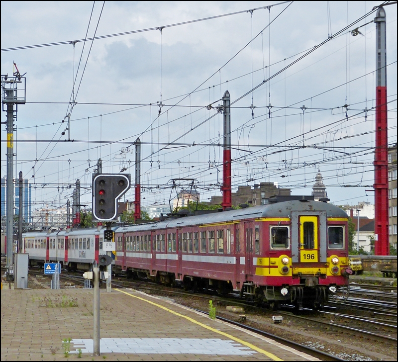Die AM 62 196 (Baujahr 1962) erreicht unversprayt zusammen mit einer AM City Rail am 27.06.2012 den Bahnhof Bruxelles Midi. (Jeanny)

Die Abschiedsfahrt f�r diese klassischen  Automotrices  soll am 23.03.2013 in Belgien stattfinden. So wie es momentan aussieht, werden diese sch�nen alten Fahrzeuge aber noch nicht in Rente geschickt, denn mit den neuen AM 08 (Desiro) gibt es soviele Probleme, dass die f�r den Fahrpalnwechsel im Dezember 2012 geplante Inbetriebnahme bis jetzt nur auf einigen Strecken erfolgt ist. Der L�wenanteil des Regionalverkehrs wird noch immer von den scheinbar unverw�stlichen AM 62 - 73 bestritten.   