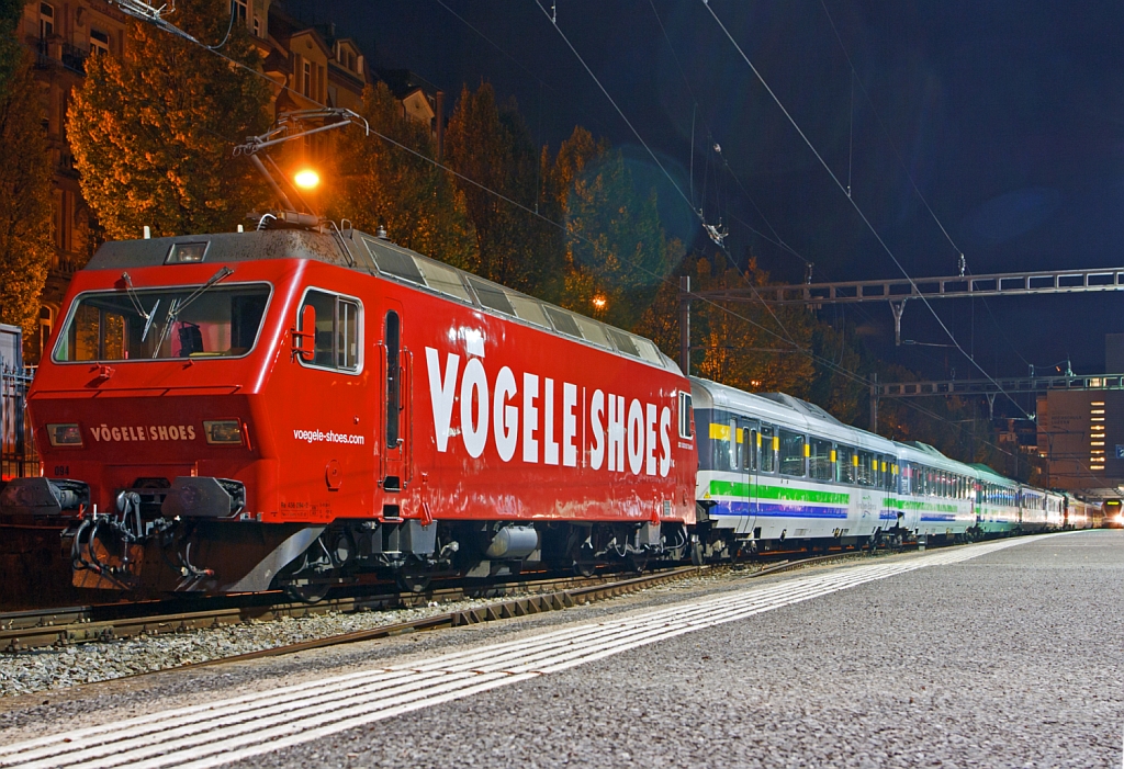 
Die SOB (Südostbahn) Re 456 094-2 (91 85 4456 094-2 CH- SOB)  Herisau  im Vögele Shoes Design ist am 29.09.2012 (3:30 Uhr) mit dem Voralpen Express in Luzern abgestellt. 

Diese vierachsige (Bo' Bo') normalspurige Lokomotive in Umrichtertechnik wurde 1987/88 von SLM und BBC für die Bodensee-Toggenburg-Bahn (BT) gebaut, die 2001 mit der SOB fusionierte. Die Lok hat eine Dauerleistung von 3200 kW, die Höchstgeschwindigkeit beträgt 130 km/h, sie hat ein Gewicht  von 68.0 t und eine Länge über Puffer von 16.60 m .