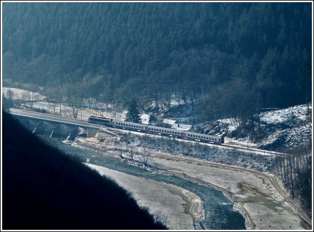 Ein eiskaltes Bild, welches die Sauerbr�cke in Michelau einmal aus einer ganz anderen Perspektive zeigt. Der Aussichtspunkt  Gringlee  in Lipperscheid bietet nicht nur einen wunderbaren Blick auf die Sauerschleife, sondern auch noch auf den IR 113 Liers - Luxemburg, welcher soeben den Tunnel Bourscheid verlassen hat und nun die Sauerbr�cke erreicht. (Jeanny)