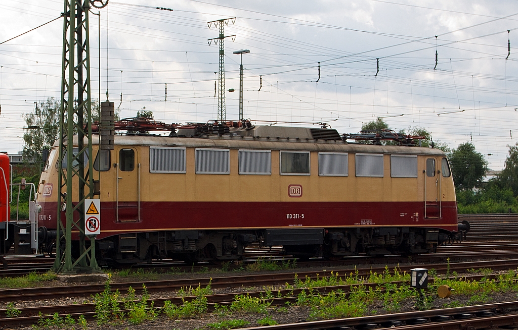 Lieder etwas vom Mast verdeckt - Die Schnellzug-Elektrolokomotive 113 311-5 ex 112 311-6  ex E 10 1311 sie steht hier am 18.07.2012 au�erhalb vom Gel�nde des DB Museum Koblenz (�ber den Zaun aufgenommen). 

Die die Baureihe 113, ehemals 112, umgezeichnet um der DR-Baureihe 212 im neuen gesamtdeutschen Nummernschema Platz zu machen, war lange Jahre eine wichtige Lokomotiv-Baureihe im bundesdeutschen Schnellzugverkehr. Die Lok war u. a. vor den Rheinpfeil-Z�gen im Einsatz, sie wurde 1963 unter der Fabriknummer 19028 bei Krauss-Maffei gebaut, dabei erhielt sie Henschel-Schnellfahrdrehgestellen f�r bis zu 160 km/h.