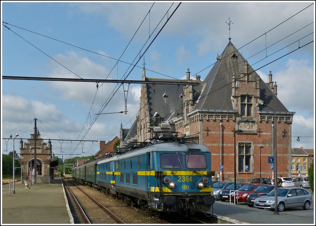 W�ren da nicht die Autos auf dem Parkplatz, k�nnte man annehmen, die Zeit sei stehen geblieben. Der Sonderzug  Adieu S�rie 23  steht am 23.06.2012 im wundersch�nen Bahnhof von Binche und wartet auf die Weiterfahrt. Das imposante Empfangsgeb�ude wurde 1857 gebaut und im Jahre 1911 feierlich er�ffnet, seit 1978 steht es unter Denkmalschutz. (Hans)