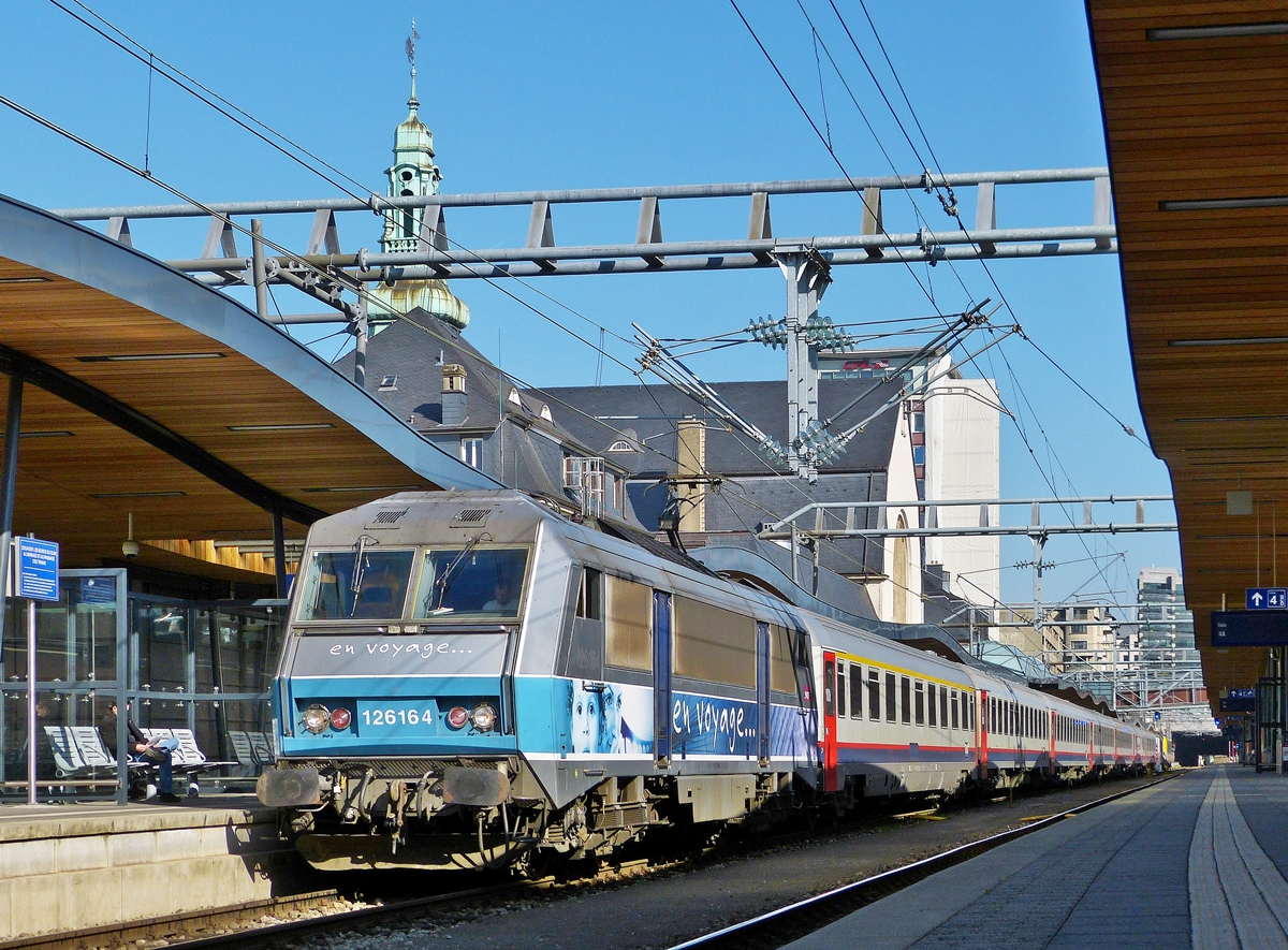 . Die Schatten werden k�rzer im Bahnhof von Luxemburg, wenn der EXP 91  Vauban  morgens am Bahnsteig steht. Wenn es  nur  8, anstatt der �blichen 9 SNCB Wagen sind und die Lok eine  en voyage  Sybic ist, dann freut sich die Fotografin.

Die BB 26164 wurde soeben an die Wagen angekuppelt und wartet nun mit dem EXP 91  Vauban  Bruxelles Midi - Basel, bestehend aus zwei 1. Klasse I 10 Wagen und sechs 2. Klasse I 6 Wagen, auf die Abfahrt im Bahnhof von Luxemburg. 11.03.2014 (Jeanny)