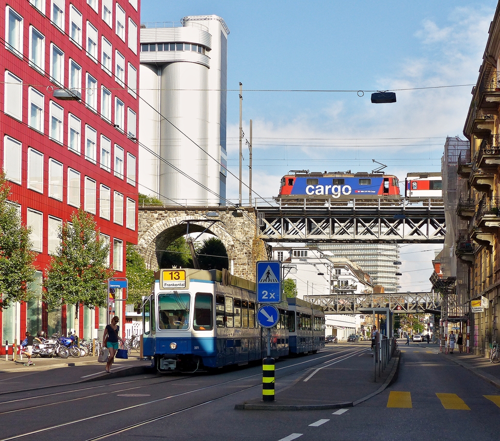 . Die VBZ Tram 2000 (Be 4/6) N� 2071 steht am 05.06.2015 an der Haltestelle Dammweg in der Limmatstrasse in Z�rich, w�hrend eine SBB Cargo Re 421 mit ihrem Zug �ber den Viadukt f�hrt. Wahrscheinlich handelt es sich um den EC 197 Z�rich HB - M�nschen Hbf via Lindau Hbf. (Jeanny)