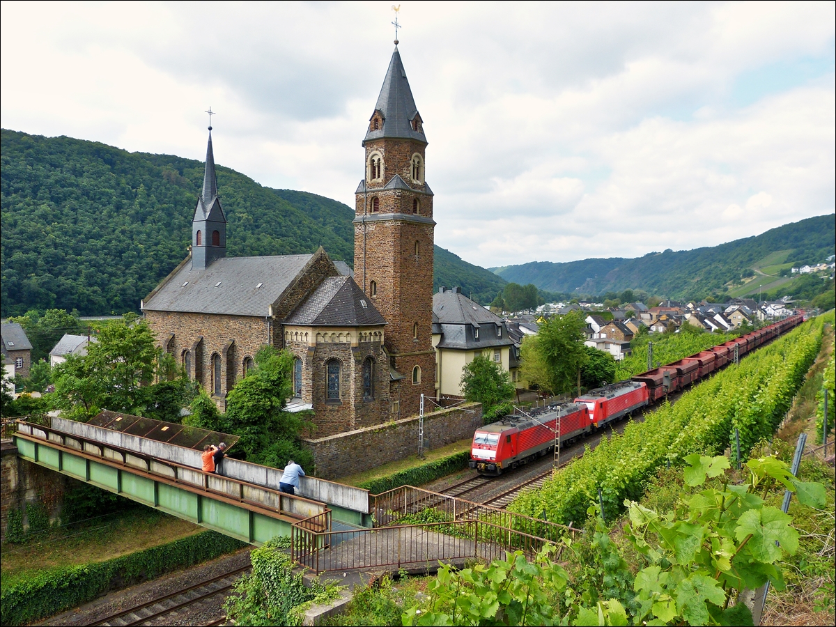 . Gleich drei Bahnfotografen stehen am 21.06.2014 auf der Fu�g�ngerbr�cke in Hatzenport, um die 189 039-1 mit ihrer Schwesterlok und dem leeren Erzzug abzulichten, als diese an der katholischen Kirche St. Rochus in Hatzenport vorbeif�hrt. (Jeanny)