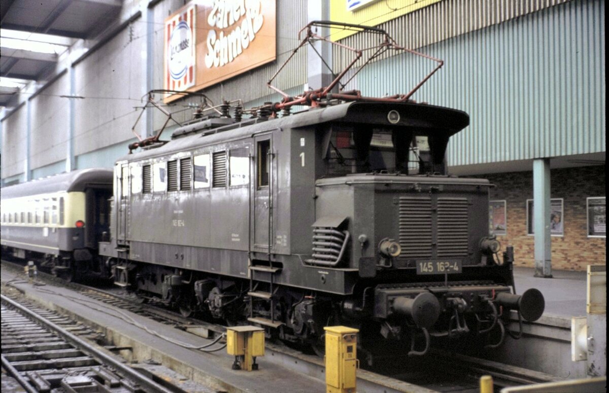 145 162-4 hat einen IC im Münchner Hbf bereitgestellt und wartet nun auf die Abfahrt des Zuges am 25.04.1982.