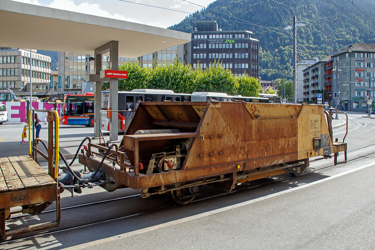 2-achsiger Talbot Schotterwagen mit 1 offenen Plattform RhB Xc 9423, ex RhB Fd 8663, am 12.09.2017 am Bahnhofsvorplatz im Zugverband eingereiht in einem aus Arosa kommenden Bauzug.

Diese Schotterwagen wurden 1965 von der Waggonfabrik Talbot in Aachen bebaut. Im Jahr 2004 wurden sie neu nummeriert, Fd 863 wurde nun zum Xc 9423.
 
TECHNISCHE DATEN:
Spurweite: 1.000 mm
Anzahl der Achsen: 2
L�nge �ber Puffer: 7.990 mm
Achsabstand: 4.000 mm 
H�he: 2.000 mm
Laufraddurchmesser: 750 mm (neu)
Eigengewicht: 7.380 kg
Ladegewicht: max. 15 t (bis 60 km/h) / 12 t (bis 70 km/h)
Max. Ladelvolumen: 9,0 m�
zul�ssige Geschwindigkeit: 60 km/h / 70 km/h

Wagenbescheibung:
Diese Talbot Schotterwagen des Typs Fd werden zum Transport und zum anschlie�enden direkten einbringen des Neuschotter ins Gleisbett verwendet. Entwickelt und gebaut wurden die Wagen von der Waggonfarbrik Talbot in Aachen. Die Wagen verf�gen dank ihrer Bauart �ber einen sehr niedrigen Schwerpunkt. Der Wagen besteht aus einem Chassisrahmen, an dem unten die beiden Achsen mit Federn, die Bremsausr�stung und die Luftbeh�lter angebaut sind. Und darauf eine Mulde mit 9m� Fassungsverm�gen f�r den Schotter. Am einen Wagenende befindet sich die Arbeitsb�hne mit Handbremskurbel und den Dossierr�dern f�r die Entladung. Die Dossierr�der erm�glichen jede Kammer einzeln, mit genau der ben�tigten Menge zu entleeren, so l�sst sich der Schotter bereits beim Entladen in der richtigen Menge dosiert, an der richtigen Stelle verteilen. Beim Entladen wird der Wagen langsam �ber den neu zu schotternden Gleisabschnitt gezogen und durch die mehr oder weniger ge�ffnete Entladevorrichtung, die sich nur gerade 35 cm �ber Schienenoberkannte befindet, f�llt der Schotter genau ins Gleisbett. Linke, Mitte und rechte Seites k�nnen dabei separat dossiert werden und das Schotterbett erh�lt bereits die Grundform der charakteristischen Form mit den Erh�hungen an den R�ndern und flach im Bereich der Schwellen. Die definitive Form erh�lt das Gleisbett anschlie�end dann durch eine Schotterplaniermaschine.

Die Schotterwagen Fd eignen sich nicht nur f�r Neuschotterung, sondern auch einfach bei einer Nachschotterung werden sie eingesetzt. Bei einer Nachschotterung ist es nicht immer zwingend notwendig, das Gleis noch mit der Schotterplaniermaschine nach zu bearbeiten. Die Fd verf�gen �ber eine durchgehende automatische Vakuumbremse mit 2-Stufigem Lastwechsel. Der Bremszylinder arbeitet auf jedes Rad, dass jeweils mit je zwei Bremskl�tzen ausger�stet ist. Die mechanische Handbremse wirkt nur auf die Achse bei der Arbeitsb�hne. 