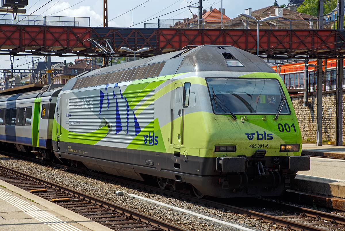 Als Portrait...
Die Re 465 001-6  Simplon/Sempione  (91 85 4465 001-6 CH-BLS) mit Werbung  Mehr durch Zug - 10 Jahre Lötschberg-Basistunnel  der BLS wird am 18.05.2018 mit einem EW III-Pendelzug (RegioExpress Neuchâtel – Bern) im Bahnhof Neuchâtel bereitgestellt.

Die Lok wurde 1994 von der SLM Winterthur unter der Fabriknummer 5638 gebaut, der elektrische Teil ist von ABB. Sie war die erste Re 465.

Die BLS Re 465 ist eine von der BLS Lötschbergbahn beschaffte elektrische, vierachsige Universallokomotive mit Umrichtertechnik. Sie ist eine Variante der Re 460 der SBB und gehört zur Lok-2000-Familie. Der Unterschied zur SBB Re 460 ist die Umrichteranlage. Im Gegensatz zur Re 460, die mit einem Umrichter pro Drehgestell ausgerüstet ist, verfügt die BLS Re 465 über einen Umrichter pro Radsatz. Somit lässt sich eine schleudernde Achse schneller und effektiver wieder in normalen Lauf bringen. Zudem besitzt die Re 465 sechspolige Asynchron-Fahrmotoren (Re 460: vierpolige Asynchronmotoren). Dadurch hat die Re 465 eine um 300 kW höhere Dauerleistung von insgesamt 6.270 kW (Stundenleistung von 7.000 kW) gegenüber der Re 460. Zudem ist die Re 465 mit der Vielfachsteuerung des Systems IIId und mit Übergangskabel BLS/BBC ausgerüstet.  Dies erlaubt die Vielfachsteuerung zum Beispiel mit Re 4/4II, Re 4/4III, Re 6/6, Re 425 oder Ae 415. Die Radsätze im Drehgestell stellen sich radial zum Gleisbogen ein.

Die Re 460 und die Re 465 sind erfolgreiche Konstruktionen. Dank ihnen gewann das schweizerische Konsortium SLM/ABB Ausschreibungen von Hochleistungslokomotiven in Norwegen (NSB El 18), Finnland (VR Baureihe Sr2) und Hongkong (KCRC TLN/TLS).

TECHNISCHE DATEN:
Spurweite:  1.435 mm (Normalspur)
Achsformel:  Bo’Bo’
Länge über Puffer:  18.500 mm
Höhe:  4.540 mm
Breite:  3.000 mm
Dienstmasse:  84 t
Zugelassene Höchstgeschwindigkeit:  160 km/h
Stundenleistung:  7.000 kW
Dauerleistung:  6.400 kW
Anfahrzugkraft:  300 kN
Treibraddurchmesser:  1.100 mm
Stromsystem:  Wechselstrom 15 kV 16,7 Hz

