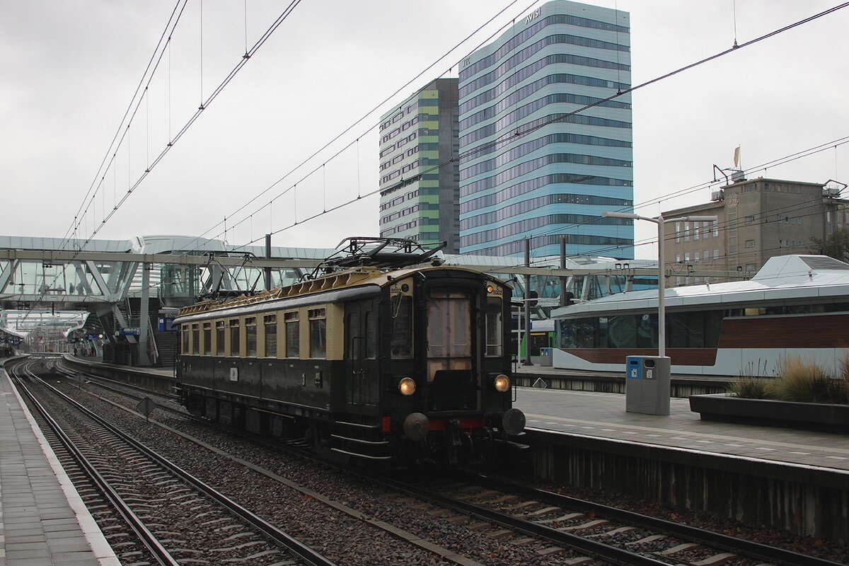 Alt und Neu ins Regen: der 101 Jahr alter Triebwagen C9002 'Blokkendoos' verlasst mit ein Sonderfahrt das 2015 geoffneter und grundlegend modernisierter Arnhem Centraal am 19 November 2025. 