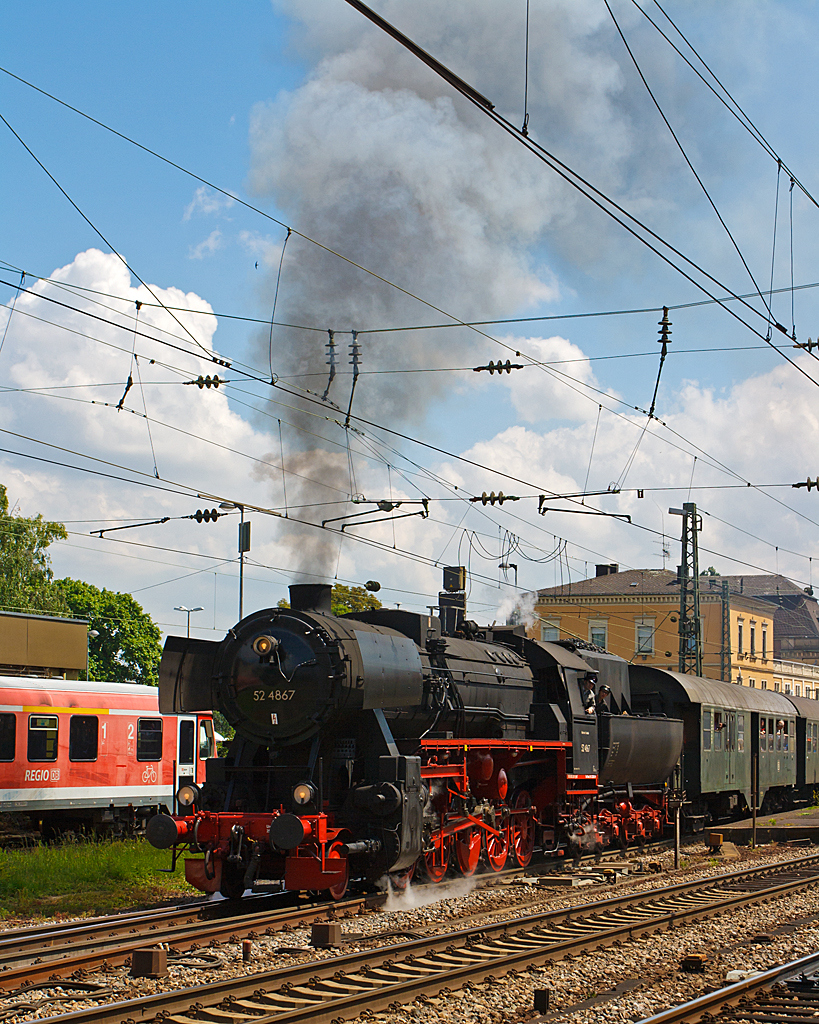 Dampfspektakel 2014 - Mir war das Gedränge auf den Bahnsteigen im Bf Neustadt an der Weinstraße einfach zu viel. 
So ging ich erst einmal ins Eisenbahnmuseum Neustadt/Weinstraße (Pfalzbahn - Museum), von hieraus konnte ich diese Aufnahme machen. 

Die Dampflokomotive 52 4867 der HEF (Historische Eisenbahn Frankfurt e. V.), ex GKB 152.4867 (Graz-Köflacher Eisenbahn- und Bergbaugesellschaft), ex ÖBB 152.4867, ex DR 52 4867, beginnt am 31.05.2014 ihre Reise mit Personenzug 79819 vom Bahnhof Neustadt (W) nach Richtung Alsenz.

Die Lok wurde 1943 bei Maschinenbau und Bahnbedarf AG in Babelsberg unter der Fabriknummer 13921 gebaut und als 52 4867 an die Deutschen Reichsbahn geliefert, nach dem Krieg verblieb sie in Österreich bis die HEF sie 1980 kaufte.

So ist diese Lok noch eine Ur-52er (keine Roko-Lok) mit Barrenrahmen.  Barrenrahmen, wie sonst allgemein bei der Deutschen Reichsbahn üblich, wurden von den Lokomotivfabriken bei den erste Lieferungen der Baureihe 52 non eingebaut. Dies aber nur solange wie noch vorgefertigte Rahmen, für die zugunsten der BR 52 eingestellte Produktion, der in den Abmessungen identischen Baureihe 50, lagerte. Später wurden sie mit geschweißtem Blechrahmen gefertigt.

TECHNISCHE DATEN der Güterzug - Dampflokomotive 52 4867: 
Hersteller: Maschinenbau und Bahnbedarf A. G. Potsdam
Fabriknummer: 13 931
Baujahr: 1943
Spurweite: 1.435 mm
Bauart: 1`E h2
Gattung: G 56.15
Treibraddurchmesser: 1.400 mm
Laufraddurchmesser:  850 mm
Länge über Puffer:  22.975 mm
Zylinderzahl: 2
Zylinderdurchmesser:  600 mm
Kolbenhub: 660 mm
Kesselüberdruck: 16 bar
Rostfläche: 3,89 m²
Verdampfungsheizfläche: 177,83 m²
Überhitzerheizfläche: 68,94 m²
Indizierte Leistung: 1.621 PS (1.192 kW)
Achslast max. : 15,3 t
Lokreibungslast:  75,5 t
Lokdienstgewicht: 84,4 t (ohne Tender)
Fahrzeugdienstgewicht: 133,1 t (mit Tender)
Wasservorrat: 30.000 l
Kohlevorrat: 8 t
Höchstgeschwindigkeit: 80 km/h (vorwärts / rückwärts)

Tender: Wannentender Typ  2'2' T 30 
Wannentender, sind  von Westwaggon in Köln, entwickelten Tender in Wannenform (daher die Bezeichnung), mit Drehgestellen und 30 m³ Wasserinhalt, sowie 10 Tonnen Kohleinhalt.