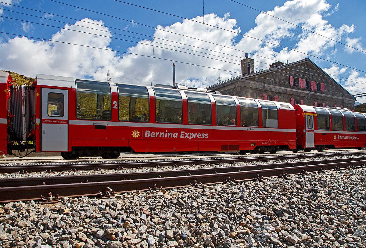 Der RhB Bps 2514 ein 4-achsiger 2.Klasse Bernina-Express Panoramawagen mit Serviceabteil der 2. Serie (Nachbau-Serie) am 06.09.2021, im Zugverband des BEX nach St. Moritz, in Ospizio Bernina.

F�r den ber�hmten Bernina-Express lie� die Rh�tische Bahn RhB 26 Panorama-Wagen in zwei Serienbauen. Gegen�ber den zuvor f�r andere Strecken gebauten Wagen, weisen die Bernina-Wagen eine um 3,2 m geringere Gesamtl�nge auf. Es entstanden neun 1.Klasse- und siebzehn 2.Klasse-Wagen, die sich gro�er Beliebtheit bei den Fahrg�sten erfreuen.

Um den Bernina-Express einheitlich mit Panoramawagen ausr�sten zu k�nnen, wurden 2006–2007 die 2.Serie von 16 Wagen (Api 1301–1306, Bps 2512–2515, Bp 2521–2526) als Nachbauserie beschafft. Diese erhielten nun allerdings luftgefederte Stadler-Drehgestelle und eine (vakuumgesteuerte) Druckluftbremse. Die vakuumgesteuerte Druckluftbremse wurde auch bei den bestehenden Wagen nachger�stet. Zudem wurde im Erstklasswagen eine rollstuhlg�ngige Toilette eingebaut. Da inzwischen das Rauchen in Schweizer Z�gen generell verboten wurde, konnte auch auf eine Trennwand f�r ein Raucherabteil verzichtet werden, bei den bisherigen Wagen wurde diese entfernt.

TECHNISCHE DATEN Bps-Wagen:
Baujahr: 2006/2007
Hersteller: Stadler
Spurweite: 1.000 mm
Anzahl der Achsen: 4
L�nge �ber Kupplung: 16.450 mm
Breite: 2.650 mm
H�he: 3.540 mm
Fu�bodenh�he: 993 mm
Drehgestellart: luftgefederte Stadler-Drehgestelle
Achsabstand im Drehgestell: 1.800 mm
Laufraddurchmesser: 685 mm (neu)
Sitzpl�tze: 43
Stehpl�tze: 49
Eigengewicht: 18 t
Nutzlast: 6,1 t
zul�ssige Geschwindigkeit: 100 km/h
Toilette: 1 komfortables geschlossenes WC-System
Lauff�hig: StN (Stammnetz) / BB (Berniabahn) / MGB (Matterhorn Gotthard Bahn)