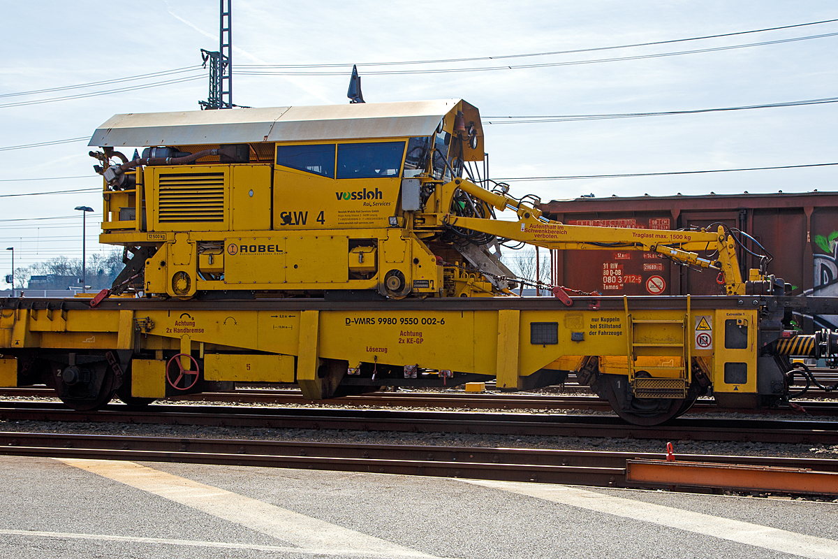 
Der ROBEL Schienenmanipulator (Ladekran) vom Typ SILAD 40.61 zum Schienenladewagen (bzw. Schienenlegewagen) SLW 4, (Schweres Nebenfahrzeug Nr. D-VMRS 99 80 9550 002-6, ex 97 30 08 904 57-3) von Vossloh Rail Service (Leipzig), ex Stahlberg Roensch Leipzig, abgestellt am 25.03.2017 beim ICE-Bahnhof Montabaur. 

Der ROBEL Schienenladezugeinrichtung-Portalkran SILAD  40.61 – SM 43 wurde 2005 von der ROBEL Bahnbaumaschinen GmbH (Freilassing) unter der Maschinen-Nr. 40.61 -SM 43 -0007 gebaut.

Wie man sieht ist der ROBEL Schienenmanipulator auch ein eigenständiges Schienenfahrzeug, mit einer Spurweite von 2.864 mm, welches auf den Schienenladewagen (zwei Rutschenwagen) und der nachfolgenden Langschienentransporteinheit der Bauart Robel (auf 4-achsigen Drehgestellwagen der Gattung Skks) fährt.
 
Technische Daten des ROBEL SILAD 40.61
Spurweite:  2.864 mm
Motor: 4-Zylinder-Dieselmotor
Antriebsart: Diesel hydrostatisch (d.h. der Dieselmotor triebt ein Hydraulikaggregat an, welches Hydraulikmotore (Hydromotore) antreibt.
Höchstgeschwindigkeit: 10 km/h
Max. Zugkraft  bei 10 km/h: 11.800N
Max. Zugkraft  bei 0-4 km/h: 3.300 N
Eigengewicht : 12.500 kg
Ladezeiten pro Schienenpaar (180 m lang):  Aufladen ca. 4 min / Abladen ca. 2 min   
Schienengewicht: bis zu 70 kg/m
Hubkraft je Schienengreiferarm bei 3,7 m Ausladung: 15.000 N  (1.500 kg) 
Schwenkkraft je Schienengreiferarm: 1000 N 
Max. Schienenlänge: 250 m (übliche Längen 120 und 180 m)

Wie das Ganze funktioniert sieht man hier:
http://www.robel.info/lib/flowplayer/index.asp?mID=40.61%20/%2040.63&id=76&bereich=1000