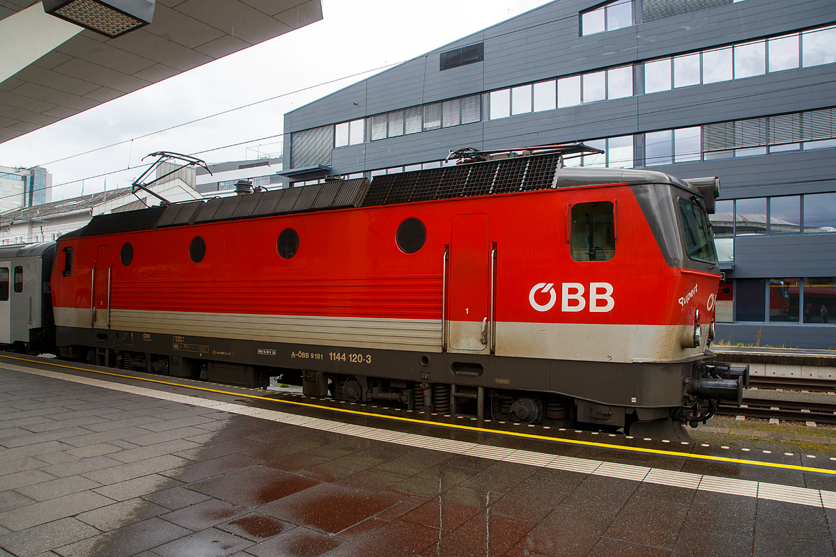 Der Rupert, die ÖBB 1144 120 „Rupert“ (A-ÖBB 91 81 1144 120-3), ex 1044 120-2, steht am 11.09.2022 im Hbf Salzburg, mit dem REX 3 (City Shuttle) nach Wörgl Hbf, zur Abfahrt bereit.

Die Universallok (ex ÖBB Reihe 1044) wurde 1994 von der Simmering-Graz-Pauker AG in Graz unter der Fabriknummer 78956 gebaut, die elektrische Ausrüstung ist von ELIN-UNION AG für elektrische Industrie. Sie wurde als 1044 120-25 an die die ÖBB (Österreichische Bundesbahnen) geliefert, 2010 erfolgte der Umbau und die Umzeichnung in die heutige ÖBB 1144 120-3.

Die Universalloks der ÖBB Reihe 1144 (ehemals Reihe 1044) ist eine elektrische vierachsige Thyristorlokomotive, die sowohl für den schweren Schnellzug- als auch Güterzugdienst im Flachland wie auch auf Bergstrecken geeignet ist. Zur Zeit der Indienststellung war sie die stärkste vierachsige Elektrolok der Welt und bis zur Beschaffung des Taurus das Paradestück der ÖBB. Mit ihrem charakteristischen Lüftergeräusch ist sie schon von weitem zu hören und dies verlieh ihr den Spitznamen „Österreichischer Alpenstaubsauger“. Die ÖBB beschaffte von 1976 bis 1995 von diesen vierachsigen Thyristor-Universallokomotiven 217 Stück. Die160 km/h schnellen und bis zu 5.120 kW starken vierachsigen Loks prägten bis zum Erscheinen der ersten TAURUS-Hochleistungslok das Bild der modernen ÖBB-Fahrzeugflotte. Die Lokomotiven der ÖBB Reihe 1044 wurden zur 1144 mit Wendezugsteuerung umgerüstet.

Geschichte:
Die bisher verwendeten Wechselstrommotoren waren an einer Leistungsgrenze von 1.000 kW pro Achse angelangt. Aus Schweden wurden erfolgversprechende Entwicklungen gemeldet, bei ihren Rb-Maschinen wurden Gleichstrommotoren mit Stufenschalter und Diodengleichrichter eingebaut. Von der Dioden- zur Thyristorsteuerung war es nur mehr ein kleiner Schritt, den ASEA aus Schweden als erster Elektronikkonzern schaffte. Von einer laufenden Bestellung von schwedischen Rc2 Lokomotiven beschafften die ÖBB 1971-1974 in zwei Serien insgesamt zehn Lokomotiven der Reihe 1043, die sich von Anfang an bestens bewährten.

Dieser Technologiesprung bedeutete einen Paradigmenwechsel im Lokomotivbau, denn nunmehr war es auf Grund der Verwendung von elektronischen Bauteilen möglich (im Wesentlichen durch eine beträchtliche Gewichtseinsparung), mehr Leistung auf einem vierachsigen Fahrzeug zu installieren (stärkerer Transformator und stärkere Fahrmotoren). Die ÖBB planten daher eine Beschaffung von je einer größeren Serie von Güter- und Personenzugslokomotiven mit unterschiedlichen Leistungs- und Geschwindigkeitskennwerten. Eine Importlösung schien nicht ausgeschlossen. Dennoch unterblieb eine solche aus mehreren Gründen. 

1974 war es endlich so weit, die österreichische Lokindustrie konnte eigene Thyristorlok präsentieren. Die zwei Prototyp-Lokomotiven, die 1044.01 und 02 wurden unter anderem mit unterschiedlichen elektronischen Steuerungen ausgestattet. Letztlich bewährte sich die 1044.02 und auch die ÖBB konnten mit der wesentlich höheren Leistung gegenüber der 1043 und mit der Höchstgeschwindigkeit von 160 km/h überzeugt werden. Da die 1044er als Universallok ausgelegt wurden, konnte auch die geplante geteilte Beschaffung für den Personen- und Güterverkehr entfallen. Eine „Österreichische Lösung“ wurde erreicht.

Nach Beseitigung der anfänglichen Probleme wurden die 1044er mit einer kurzen Unterbrechung bis 1995 weiter gebaut. Die insgesamt 217 Loks wurden von Anfang an grenzüberschreitend bis nach Norddeutschland eingesetzt. Die 1044.01 wurde sogar zur ersten ÖBB Hochgeschwindigkeitsversuchslok umgebaut und erhielt die Nummer 1044.501. Erst mit der Lieferung der TAURUS-Hochleistungsloks begann ihr Stern ein wenig zu sinken. In den letzten Jahren wurden alle 1044er modifiziert und auch mit einer Wendezugsteuerung ausgestattet. Dadurch sind die nunmehr als 1144 bezeichneten Fahrzeuge noch vielseitiger einsetzbar. Besonders imposant sind die 44er im Einsatz auf der Semmeringbahn, wo sie ihrem Ruf als „Österreichischer Alpenstaubsauger“ mehr als nur gerecht werden. Man hört die Loks schon von weitem und es ist beeindruckend, wie die mittlerweile bis zu 38 Jahre alten Fahrzeuge noch immer unermüdlich ihren schweren Dienst leisten.

TECHNISCHE DATEN:
Gebaute Anzahl: 217
Baujahre: 1976 bis 1995
Hersteller (mechanisch): SGP Simmering-Graz-Pauker AG (Graz)
Hersteller (elektrisch): BBC (ABB), ELIN, Siemens Wien
Spurweite:  1.435 mm (Normalspur)
Achsformel:  Bo’Bo’
Länge über Puffer:  16.100 mm
Begrenzungslinie: UIC 505-1
Drehzapfenabstand: 8.000 mm
Achsabstand in Drehgestell: 2.900 mm
Raddurchmesser:  1.300 mm (neu) / 1.210 mm (abgenutzt)
Kleinster bef. Halbmesser (V  max= 10 km/h): 120 m 
Dienstgewicht: 84 t
Höchstgeschwindigkeit: 160 km/h (1044.501, ex 1044.01 nach Umbau 220 km/h)
Stundenleistung: 5.280 kW
Dauerleistung: 5.000 kW
Anfahrzugkraft: 340 kN
Dauerzugkraft:  208,9 kN
Stromsysteme: 15kV/16,7Hz AC
Antriebsart: Thyristor-Gleichrichter, Mischstrom-Fahrmotoren mit
Reihenschluß- (45 %) und Fremderregung (55 %), BBC- Federantrieb
Anzahl der Fahrmotoren: 4
Dynamisches Bremssystem: Elektrodynamische Gleichstrom-Widerstandsbremse
Nenn- / Höchstleistung der dynamischen Bremse:  2.400 / 3.720 kW
Max. Bremskraft der dynamischen Bremse: 115 kN
Bremsbauart: On-GPR-E m Z, ep. / NBÜ nach „DB-Norm“
Zugheizung: 800 kVA

Quellen: ÖBB, ÖBB-Produktion GmbH und Wikipedia
