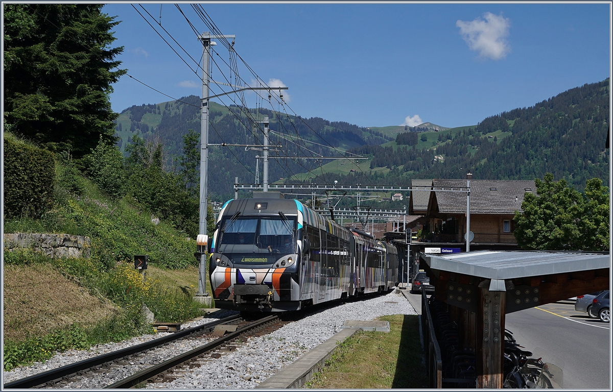 Der von Sarah Morris als  Monarch  gestaltete MOB Be 4/4 5001 mit seinen Steuerwagen ABt 341 und Bt 241 als Regionalzug 2418 von Rougemont nach Zweisimmen unterwegs und verlässt nach einem kurzen Halt Gstaad.

2. Juli 2020