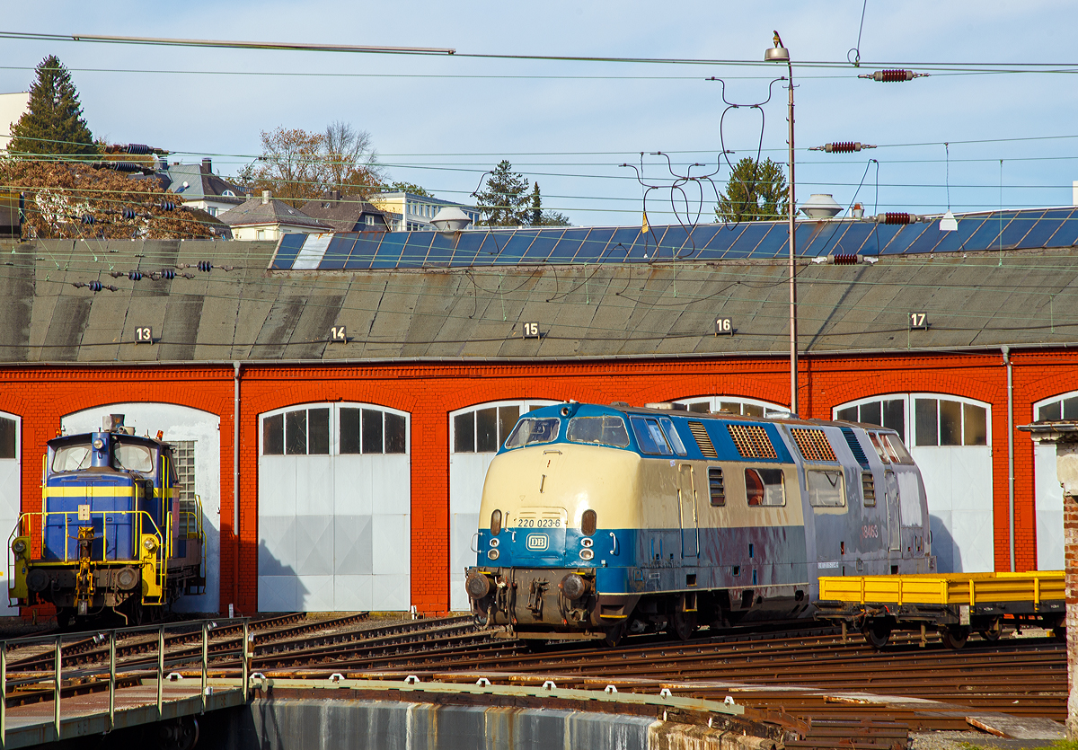 Die 220 015-2 (ex 92 80 1220 015-2 D-MEH), ex SBB 843 463-1, ex SBB Am 4/4 18463, ex DB V 200 015, der Deutsche Privatbahn GmbH ist am 30.10.2019 vor dem Siegener Lokschuppen abgestellt. Hier wartet sie wohl auf eine neue Lackierung durch Rail-Design Bäcker. Die vorne angeschriebene Bezeichnung  220 023-6  ist nur eine Betreiberbezeichnung des vorherigen Eigentümers MEH - Gesellschaft der Förderer der Museumseisenbahn Hamm e. V..

Die Lok der DB-Baureihe V 200.0 wurde 1957 von MaK (Maschinenbau Kiel) unter der Fabriknummer 2000015 gebaut und als V 200 015 an die Deutschen Bundesbahn geliefert. Zum 01.01.1968 erfolgte die Umzeichnung in DB 220 015-2, als diese fuhr sie bis zur Ausmusterung 1984. Im Jahr 1986 wurde sie an die SBB verkauft, die sie durch die Regentalbahn AG aufarbeiten lies und 1988 als Am 4/4 18463 (später 843 463-1) in Dienst stellte, bis sie dort wieder 1995 ausgemustert wurde. 
Weitere Stationen waren:
1997 bis 2010 Gesellschaft zur Erhaltung von Schienenfahrzeugen Stuttgart e. V.
2010 bis 2015 Brohltal-Eisenbahn (als Ersatzteilspender)
2015 bis 2019 MEH - Gesellschaft der Förderer der Museumseisenbahn Hamm e. V.
Seit 2019 nun DP Deutsche Privatbahn GmbH (Altenbeken)

Die DB-Baureihe V 200.0 war eine der ersten Diesel-Streckenlokomotiven der Deutschen Bundesbahn. Die V 200 beförderte hochwertige Schnellzüge auf allen wichtigen Hauptstrecken. Durch die fortschreitende Elektrifizierung wurden die Maschinen jedoch aus diesen Diensten nach und nach verdrängt. Im Betrieb wurden die V 200.0 durch steigende Zuglasten öfter überfordert, so dass es zu Schäden kam. Die Deutsche Bundesbahn stellte daher ab 1962 die stärkere Baureihe V 200.1 (später Baureihe 221) in Dienst.
Die V 200 hatte zwei schnelllaufende V12-Dieselmotoren mit hydraulischer Kraftübertragung. Beide Antriebsgruppen waren unabhängig voneinander. Jeder Motor trieb dabei über einen Drehmomentwandler eines der beiden Drehgestelle an. Die Höchstgeschwindigkeit betrug 140 km/h. Es kamen zwei Motorentypen von Maybach-Motorenbau (Maybach MD 650) und Mercedes-Benz (MB 12 V 493 TZ) sowie zwei Getriebetypen von Maybach und Voith zum Einsatz. Motoren und Getriebe waren so konstruiert, dass sie freizügig zwischen der V 200, der V 100.10, der V 80 sowie den Dieseltriebwagen-Baureihen VT 08, VT 11 und VT 12 getauscht werden konnten. 

Die Schaltpunkte der beiden Getriebe sind leicht zueinander versetzt, um beim Gangwechsel zu starke Rucke im Zug zu vermeiden. Während das Maybach-Mekydro-Getriebe K 104 über nur einen Drehmomentwandler und vier mechanische Gänge verfügte, wurde der Gangwechsel im Dreigang-Getriebe Voith L306 durch Umschaltung zwischen drei unterschiedlich dimensionierten Drehmomentwandlern realisiert.

Die Getriebe sind unter den Führerständen montiert. Die Anlasslichtmaschinen befinden sich unmittelbar über den Pufferbohlen. Sie sind über einen Durchtrieb des Getriebes mit dem Dieselmotor verbunden. Die Lokomotiven verfügen zwischen den beiden Führerständen über nur einen Maschinenraum-Seitengang. Auf der gegenüberliegenden Seite sind einige Hilfsbetriebe untergebracht. Unmittelbar hinter den Führerständen sind die Motoren angeordnet. Der Dampfkessel für die Zugheizung befindet sich in Lokmitte. Zum Ausbau der Großgeräte verfügt das Dach über abnehmbare Hauben.

Der Heizkessel dient der Vorwärmung der Maschinenanlage und der Versorgung des Wagenzuges mit Heizdampf. 

Als Führerbremsventil ist bei den Serienloks ein D2-Selbstregler eingebaut, bei der Vorserie ein Knorr Nr. 10. Die indirekte Druckluftbremse entspricht der mehrlösigen Bauart Westinghouse. 

Die Lokomotiven besaßen die „Vielfachsteuerung Bauart 1949“ und waren damit wendezug- und mehrfachtraktionsfähig. Technisch konnten damit bis zu drei Lokomotiven gemeinsam gesteuert werden. An Sicherheitseinrichtungen waren von Anfang an Indusi I 54 und eine Zeit-Weg-Sifa vorhanden. Ebenfalls der Sicherheit dienten eine Brandmeldeanlage und die Möglichkeit, das Kesselspeisewasser zum Feuerlöschen einzusetzen.

TECHNISCHE DATEN (Serie):
Gebaute Stückzahl:  86 (davon 5 Vorserien Loks)
Spurweite: 1.435 mm
Achsformel:  B’B’
Länge über Puffer:  18.530 mm
Drehzapfenabstand:  11.500 mm
Achsabstand im Drehgestell: 3.200 mm
Dienstgewicht:  ca. 80 t
Höchstgeschwindigkeit:  140 km/h
Leistung: 1.768 kW (2x 884 kW / 2x 1200 PS)
Anfahrzugkraft: 	235 kN
Dauerzugkraft: 	177 kN
Motorbauart: 	2 × V12-Zylinder-Diesel
Motor-Nenndrehzahl: 1.500 U/min
Leistungsübertragung:  hydraulisch

