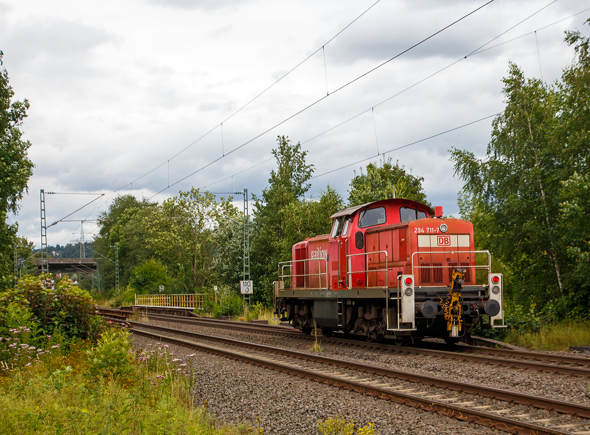 Die 294 711-7 (98 80 3294 711-7 D-DB), eine remotorisierte V 90 der DB Cargo AG fährt am 31.07.2021 als Tfzf (Triebfahrzeugfahrt) bzw. Lz (Lokzug) durch Siegen-Eiserfeld in Richtung Siegen. 

Die Lok wurde 1971 bei MaK in Kiel unter der Fabriknummer 1000519 gebaut und als 290 211-2 an die DB geliefert. Die Ausrüstung mit Funkfernsteuerung (Typ Krauss-Maffei) und Umzeichnung in 294 211-8 erfolgte 1996. Im Jahr 2003 erfolgte durch die DB Fahrzeuginstandhaltung GmbH, in Cottbus eine Remotorisierung durch einen neuen MTU 90° V-8-Zylinder-Dieselmotor mit Common-Rail-Einspritzsystem, Abgas-Turbolader und Ladeluftkühlung, vom Typ 8V 4000 R41. Der Motor ist auf eine Leistung von 1.000 kW (1.341 PS) bei 1.800 U/min gedrosselt. Auch wurden eine neue Lüfteranlage und ein neuer Luftpresser eingebaut, zudem bekam die Lok ein Umlaufgeländer.
Durch die Remotorisierung und den Umbau erfolgte auch die Umzeichnung in die heutige 294 711-7.
