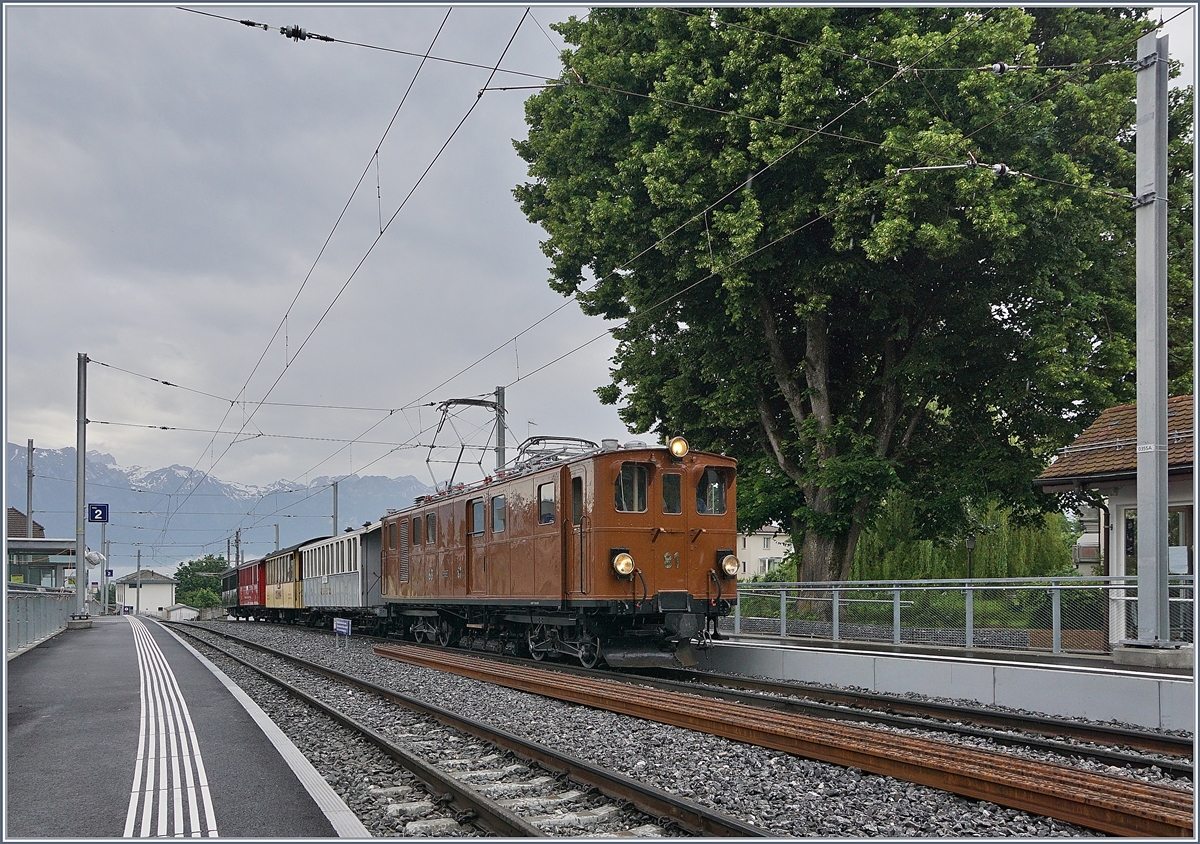Die Blonay Chamby Bernina Bahn Ge 4/4 81 bei der Rückfahrt nach Blonay mit ihrem  Riviera Belle Epoque  fährt in St-Légier Gare durch. Trotz grundlegendem Umbau der Station St-Légier Gare steht das Ensemble des schönen grossen Baums sowie des kleinen Stationsgebäude weiterhin an ihren Platz.

9. Juni 2019