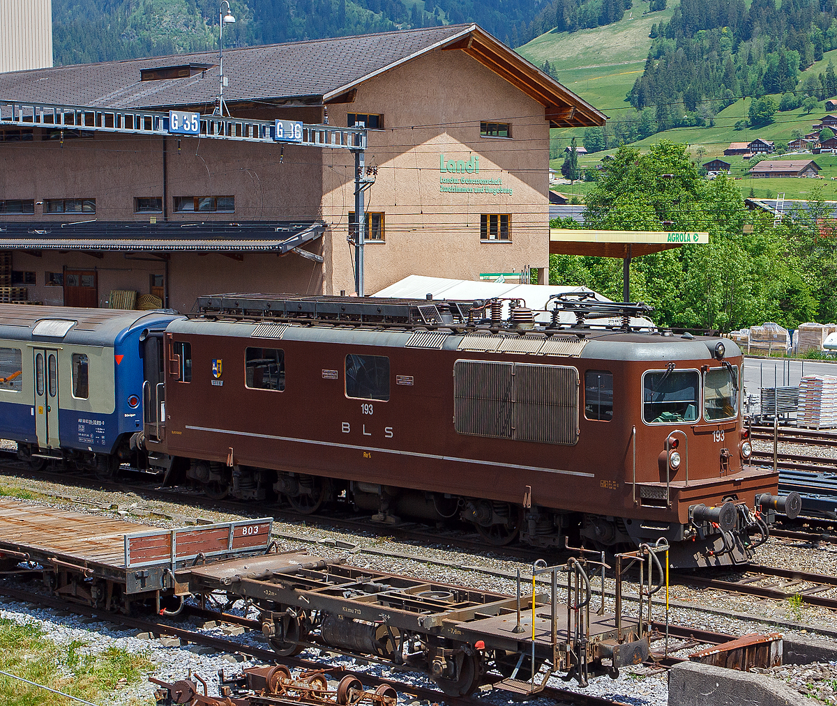 Die BLS Re 4/4 – 193 „Steg“ (Re 425 193) ist am 28.05.2012 beim Bahnhof Zweisimmen abgestellt, aufgenommen aus einfahrendem Goldenpass Zug.

Die Lok wurde 1983 von der Schweizerische Lokomotiv- und Maschinenfabrik (SLM) in Winterthur unter der Fabriknummer 5225 gebaut, die elektrische Ausrüstung ist von BBC. 

Die BLS hat mit der Eröffnung der Strecke Spiez - Frutigen den elektrischen Betrieb mit 15 kV / 16 2/3 Hz im Jahre 1910 eingeführt. Lange war der Pioniergeist der BLS wegweisend für die Triebfahrzeugentwicklung in der Schweiz. Die Lokomotiven aus der Anfangszeit der Elektrifizierung waren den Forderungen der modernen Zugförderung nicht mehr gewachsen. Die BLS begann zusammen mit SLM und BBC Anfang der sechziger Jahre eine moderne Universallokomotive (Ae 4/4 II) zu entwickeln. 

Die BLS Re 4/4 (ursprünglich Ae 4/4 II) wurde von 1964 bis 1983 als Universallokomotive mit guter Bergleistung von der Bern-Lötschberg-Simplon-Bahn (BLS) beschafft, um die Züge mit höheren Geschwindigkeiten befördern zu können und um die Lokomotiven der Gründungsjahre abzulösen. Mit 35 gebauten Lokomotiven wurde die Re 4/4 die größte Lokomotivserie der BLS-Gruppe.

Aufgrund der sehr erfolgreichen Konstruktion der Ae 4/4 der BLS, der ersten laufachslosen Hochleistungslokomotive der Welt, leiteten die BLS und SLM die Neuentwicklung von dieser Reihe ab. Das ist auch an der Kastenform eindeutig zu erkennen, die Anordnung der Einstiege an der Lokfront wurde von der Ae 4/4 übernommen. Das Fahrgestell ist ähnlich demjenigen der SBB Re 4/4 II. Doch da hören die Gemeinsamkeiten zu dieser auch sehr erfolgreichen Baureihe auf. So wird die Kraft mit einer anders konstruierten Tiefzuganlenkung und Seilzug auf die Schienen gebracht. Statt Sandereinrichtungen besitzt die Lok Schienendüsen. Bei vielen Versuchen und Vergleichen mit z. T. ausländischen Lokomotiven stellt die Re 4/4 noch heute ihre enorme Leistungsfähigkeit am Berg unter Beweis. Einen 630-Tonnen-Zug kann die Lok auf einer 26-‰-Steigung mit 80 km/h befördern. Die Stundenzugkraft beträgt 226 kN bei 77,5 km/h. So wurde damals, aufgrund der mit der Thyristorsteuerung ausgerüsteten Re 4/4 161 absolvierten Vorführungs- und Probefahrten am Semmering, die ÖBB 1044 entwickelt.

Die Ansteuerung der Fahrmotoren erfolgt über den BBC-Trafo, Stufenschalter mit Luftmotor auf den Diodengleichrichter. Die elektrische Bremse, bis 600 A Bremsstrom, wirkt mithilfe der Dachwiderstände. Die Lokomotiven können in Vielfachsteuerung unter sich oder mit den BLS Re 465 verkehren. Ebenfalls möglich war einige Jahre lang die Vielfachsteuerung mit den inzwischen ausrangierten Ae 8/8 und Ae 4/4, nachdem diese Loktypen mit Vielfachsteuerung ausgerüstet worden waren. Bei den Re 4/4 war die Vielfachsteuerung ab 1967 eingebaut worden.

Die ersten fünf Maschinen waren bei Ablieferung nur für 125 km/h zugelassen und wurden dementsprechend bis 1969 als Ae 4/4 II 261–265 bezeichnet. Die Änderung der Serienbezeichnung erfolgte nachdem die Zulassung für die Geschwindigkeitsreihe „R“ erteilt war. Dazu mussten Achsseitenfederungen eingebaut werden, um die Schienenbeanspruchung zu vermindern. Die Gummisekundärfederung der ersten fünf Lokomotiven bewährte sich nicht und wurde durch Schraubenfedern mit einem parallelen Stoßdämpfer ersetzt. Seither tragen die Lokomotiven die Bezeichnung Re 4/4.

Ab der Lokomotive Re 4/4 174 wurde der Kasten um 370 mm verlängert, um später die automatische Kupplung einbauen zu können. Die Re 4/4 161 bis 189 sind mit Scherenstromabnehmern ausgerüstet, während die Re 4/4 190 bis 195 mit Einholstromabnehmern geliefert wurden.

TECHNISCHE DATEN der Re 4/4 174 bis 195:
Spurweite:  1.435 mm (Normalspur)
Achsformel:  Bo’Bo’
Länge über Puffer:  15.470 (15.100 mm Lok 161 bis 173)
Drehzapfenabstand: 7.900 mm
Achsabstand im Drehgestell: 2.800 mm
Treibraddurchmesser:  1.250 mm
Höhe:  4.500 mm
Breite:  2.950 mm
Dienstgewicht:  80 t
Höchstgeschwindigkeit: 140 km/h
Dauerleistung:  4.980 kW (6.770 PS)
Anfahrzugkraft:  320 kN
Dauerzugkraft: 236 kN
Anzahl Fahrmotoren: 4
Übersetzungsverhältnis: 1 : 3,346
Stromsystem:  Wechselstrom 15 kV 16,7 Hz
