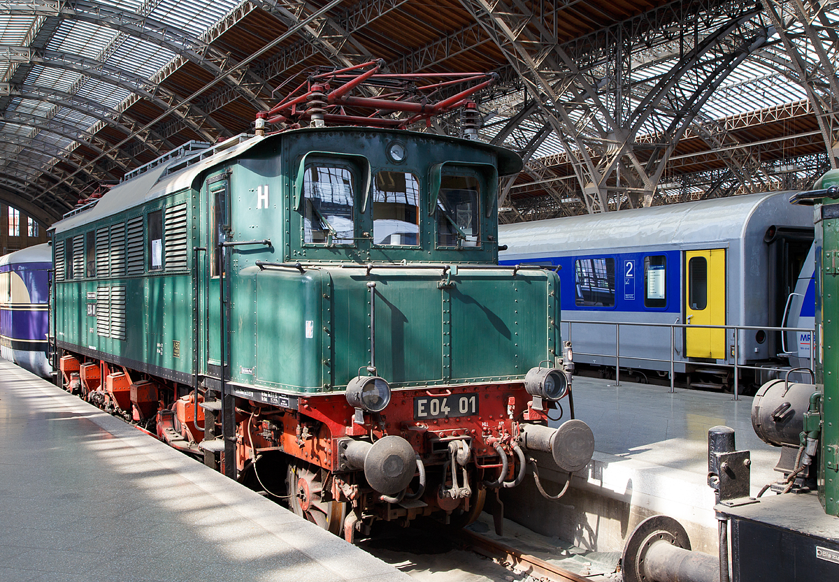 Die E 04 01 (ex DR  204 001-2, ex DRG E 04 01) ausgestellt im Leipziger Hauptbahnhof auf dem Museumsgleis bzw. Traditionsgleis (Gleis 24), hier am 21.05.2016. Eigentümer von dem Fahrzeug ist das DB Museum. Die E 04 01befindet sich im Zustand der DDR Reichsbahn.

Die Lok wurde 1932vvon AEG in Hennigsdorf unter der Fabriknummer 4681gebaut und an die DRG geliefert. Beheimatungen  waren Leipzig-Hbf-West und Magdeburg-Hbf, so verblieb sie nach dem Krieg im Bereich der sowjetischen Besatzungszone (SBZ). Aufgrund der Anordnung der Besatzungsmacht wurde am 29.03.1946 der elektrische Zugbetrieb in der SBZ eingestellt und alle Anlagen und Lokomotiven in die Sowjetunion abtransportiert. 1952/53 wurden die Anlagen und Lokomotiven größtenteils zurückgegeben, so dass im Bereich  der DDR Reichsbahn erneut ein elektrischer Zugbetrieb aufgebaut werden konnte. Auch die E 04 01 kehrten zurück und wurden mit großem Aufwand wieder instand gesetzt und fuhr so bis zu ihrer Ausmusterung am 28.04.1976.

Allgemeines zur Baureihe E 04 (DB 104 / DR 204):
Die von der AEG für die sächsischen Flachlandstrecken entwickelte E 04 basiert auf den Erfahrungen der Baureihe E 17, jedoch mit einfachem Blechrahmen und drei Fahrmotoren.

Zunächst kamen zwischen Ende 1932 und Mitte 1933 die acht Maschinen E 04 01-08 beim Bw Leipzig West in den Schnellzugdienst. Im Mai und Juni 1933 wurden die E 04 09 und E 04 10 für Versuchsfahrten beim Bw München Hbf in Betrieb genommen. Die E 04 09 erreichte am 28. Juni 1933 mit einem 309-t-Zug auf der Strecke München – Stuttgart eine Höchstgeschwindigkeit von 151,5 km/h. Die zulässige Höchstgeschwindigkeit wurde nach den Versuchsfahrten für diese beiden Maschinen auf 130 km/h erhöht.
In den Jahren 1933/34 folgten 11 weitere Maschinen für den Einsatz auf Bayerischen Strecken, die durch eine andere Getriebeübersetzung eine Höchstgeschwindigkeit von 130 km/h besaßen und mit einer zusätzlichen Laufradbremse versehen waren. Als dritte  Serie  folgten Ende 1935 die E 04 22 und E 04 23 (mit Einrichtung für Wendezugbetrieb).
Nach dem II. Weltkrieg waren nur noch neun der 23 E 04 einsatzfähig. Die Maschinen E 04 17 bis E 04 22 verblieben bei der DB. Bei der DR verblieben die siebzehn Maschinen E 04 01-E 04 16 und E 04 23. Bis auf die E 04 04 und E 04 13 wurden alle Loks wieder betriebsfähig aufgearbeitet. Die DB bezeichnete die E 04 ab 1.1.1968 als Baureihe 104, die DR ab 1.7.1970 als Baureihe 204.
Die DB-Loks waren in München und Osnabrück stationiert. Ende 1980 waren nur die 104 018 und 104 020 für Sonderdienste im Einsatz. Am 31.7.1981 wurde die 104 018 abgestellt. Die 104 020 wird als Museumslokomotive unterhalten.
Bei der DR begann im Jahre 1974 die Ausmusterung. Bis Ende 1976 waren auch die letzten drei (204 005, 204 007 und 204 015) dieser Baureihe abgestellt und im Januar 1977 ausgemustert worden, wobei ein Teil von ihnen z.B. als Weichenheizungsanlage Verwendung fanden.

TECHNISCHE DATEN:
Spurweite: 1.435 mm (Normalspur)
Achsenanordnung: 1‘Co1‘  
Länge über Puffer : 15.120 mm
Dienstgewicht: 92 t
Achslast: 18,4 t
Treibraddurchmesser : 1.600 mm 
Laufraddurchmesser:  1.000 mm  
Höchstgeschwindigkeit : 110 km/h (130 km/h ab E 04 09 ) 
Stundenleistung: 2.190 kW 
Dauerleistung:  2.010 kW
Anzahl der Motoren: 3
Stromsystem: 16 2/3 Hz, 15 kV
Antrieb:  Kleinow-Federtopf
Anfahrzugkraft: 177 kN (152 kN ab E 04 09) 
