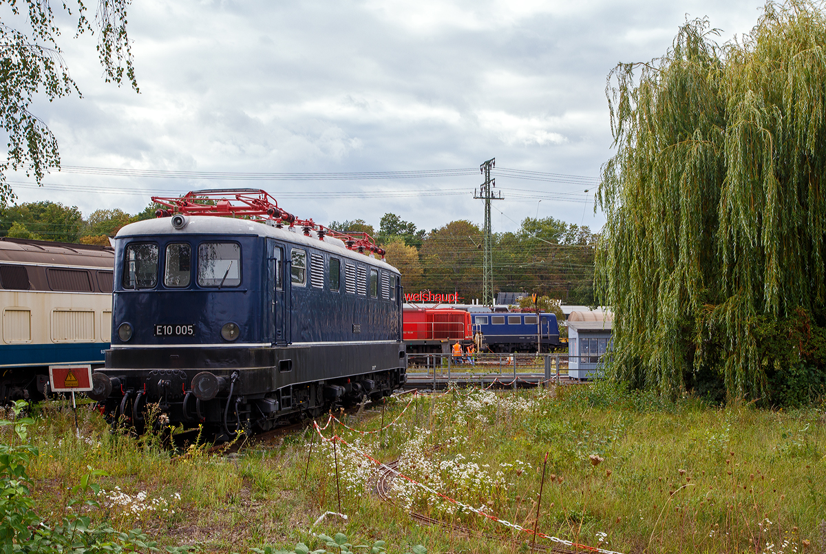 Die E 10 005, später 110 005–6, steht am 04.09.2020 im DB Museum Koblenz-Lützel. Diese fünfte Vorserien E 10 wurde 1953 von Henschel & Sohn in Kassel unter der Fabriknummer 28467 gebaut, die Elektrik wurde von AEG unter der Fabriknummer 7174 geliefert. Zum 30.08.1979, nach einer Laufleistung von 4,34 Mio. km, erfolgte die Ausmusterung bei der DB und 1980 wurde sie zur Museumslok.

Die Vorserienlokomotiven wurden weitgehend von der Industrie entwickelt, wobei verschiedene Komponenten ausprobiert wurden:
Die E 10 001 stammt im mechanischen Teil von Krauss-Maffei und im elektrischen Teil von AEG. Sie besaß einen Alsthom-Gelenkhebelantrieb.
Die E 10 002 stammt mechanisch von Krupp und elektrisch von BBC und hatte einen BBC-Scheibenantrieb.
Die E 10 003 kam von Henschel und SSW und hatte einen SSW-Gummiringfederantrieb.
Die E 10 004 lieferten Henschel und AEG und sie wurde durch einen Sécheron-Lamellenantrieb angetrieben. Baugleich mit ihr war die E 10 005, die 1953 nachgeliefert wurde, um die Lokomotiven auch im täglichen Betrieb testen zu können.

Die neuen Lokomotiven sollten Schnellzüge mit 700 t auf 10 ‰ mit 90 km/h und Güterzüge mit 1300 t auf 5 ‰ mit 70 km/h befördern können. Die Höchstgeschwindigkeit war mit 125 km/h angesetzt. Eine Zugkraft von 7 t am Radumfang war gefordert, wobei 6 t bereits 5 Sekunden nach dem Anfahren aus dem Stillstand erreicht werden mussten. Die Erwärmung der Fahrmotoren durfte 90 Grad nicht überschreiten. Auch durften Schwankungen bei der Fahrdrahtspannung zwischen 10,5 und 18,5 kV keine Betriebsstörungen verursachen. Die Loks sollten zweiachsige Drehgestelle mit Drehzapfen erhalten, wobei die Zugkraftübertragung über den Brückenrahmen und nicht mehr über die Drehgestelle (wie bei der E 44) erfolgen sollte. Auf Vorbauten, wie sie bei den Vorkriegselloks aus Sicherheitsgründen zu finden waren, glaubte man verzichten zu können. Schließlich war Vielfachsteuerung für den Einsatz in Doppeltraktion sowie die Ausrüstung für den Wendezugeinsatz einzubauen.

Gegenüber den Vorplanungen wurde die Höchstgeschwindigkeit auf 130 km/h heraufgesetzt und die Baureihenbezeichnung in E 10 umgewandelt. Entsprechend dem Schweizer Vorbild waren es Drehgestell-Lokomotiven mit einzeln angetriebenen Achsen jedoch mit unterschiedlichen Antrieben.

Die Auslieferung der Loks erfolgte im Zeitraum zwischen dem 23. August 1952 (E 10 001) und dem 23. März 1953 (E 10 005).

Die E 10-VorserienIoks sollten dazu dienen, möglichst viele neue Bauteile auf ihre Verwendbarkeit für die künftigen Serienloks zu testen. Deshalb unterschieden sie sich weitgehend voneinander und von den folgenden Serienloks.
Einige Bauteile waren jedoch im Prinzip gleich aufgebaut und nur in der Ausführung etwas verschieden. Dazu gehörte der Brückenrahmen, der bei allen Loks aus kastenförmig zusammengeschweißten Stahlblechen bestand. Er setzte sich jeweils aus zwei Längsträgern, zwei Kopfstücken, drei Querträgern (für die Drehzapfen und den Trafo) sowie Deckblechen zusammen und musste die Zug- und Stoßkräfte aufnehmen.
Auch der Kastenaufbau war bei allen Vorserienloks ähnlich konstruiert. Er bestand jeweils aus einem selbsttragenden Gerippe von Stahlprofilen, die auf den Brückenrahmen geschweißt waren und durch angeschweißte Mantelbleche verkleidet wurden.

Die fünf Vorserien-Lokomotiven der Baureihe E 10.0 wurden zwischen 1975 und 1979 ausgemustert. Erhalten sind die Museumslokomotiven E 10 002 und E 10 005.

TECHNISCHE DATEN der E10 004 und 005:
Spurweite: 1.435 mm
Achsanordnung: Bo´Bo´
Länge über Puffer: 15.900 mm
Treibraddurchmesser: 1.250 mm (neu)
Dienstgewicht: 80 t
Achslast: 20 t
Höchstgeschwindigkeit : 130 Km/h
Anfahrzugkraft: 255 kN
Dauerzugkraft: 118 kN
Nennleistung: 3.440 kW
Anzahl Fahrmotoren 4
Stromsystem: Einphasen-Wechselstrom 15 000 V, 16 2/3 Hz 