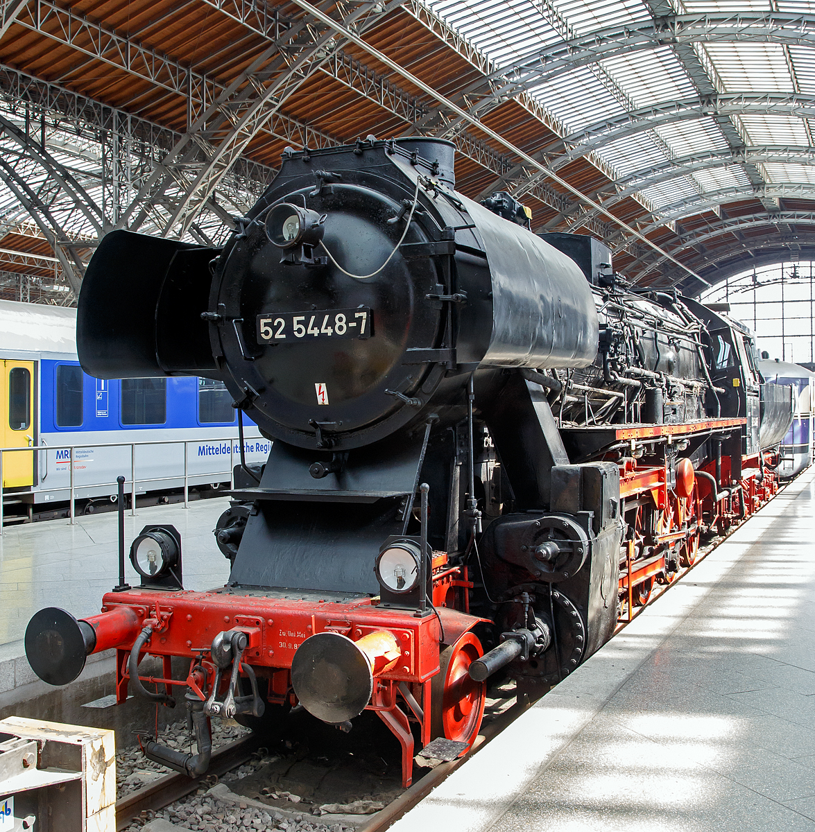 
Die ex DR 52 5448-7 (seit 1992 im eigentum der EMBB - Eisenbahnmuseum Bayrischer Bahnhof e.V.) ausgestellt im Leipziger Hauptbahnhof auf dem Museumsgleis bzw. Traditionsgleis den Gleis 24, hier am 21.05.2016. 

Die 52 5448 mit einen Barrenrahmen wurde 1943 von Schichau-Werke in Elbing unter der Fabriknummer 3726 gebaut, sie war die letzte BR 52 mit Altbaukessel im Planbetrieb der DR. Seit 1959 hat sie einen Mischvorw�rmer und Achslagerstellkeile.