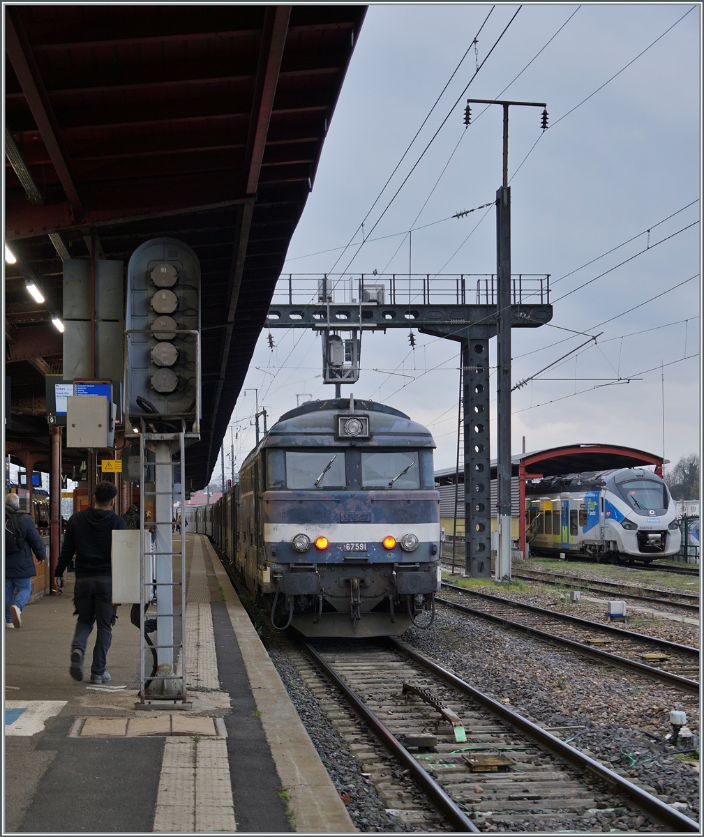 Die formschöne Diesellok steht in Strasbourg und wartet mit ihrem TER 831830 (ab 17:01) nach Saint-Dié-des-Vosges (an 18:50) auf die Abfahrt.
Der Zug besteht auf zwei RRR Garnituren. Um die gleiche Anzahl Personne zu befördern wären drei bis vier Régiolis nötig, die aber durch die kurzen Umläufe tagsüber nur rumstehern würden, so dass die SNCF (noch) auf die BB 67400 zurückgreift.

12. März 2024