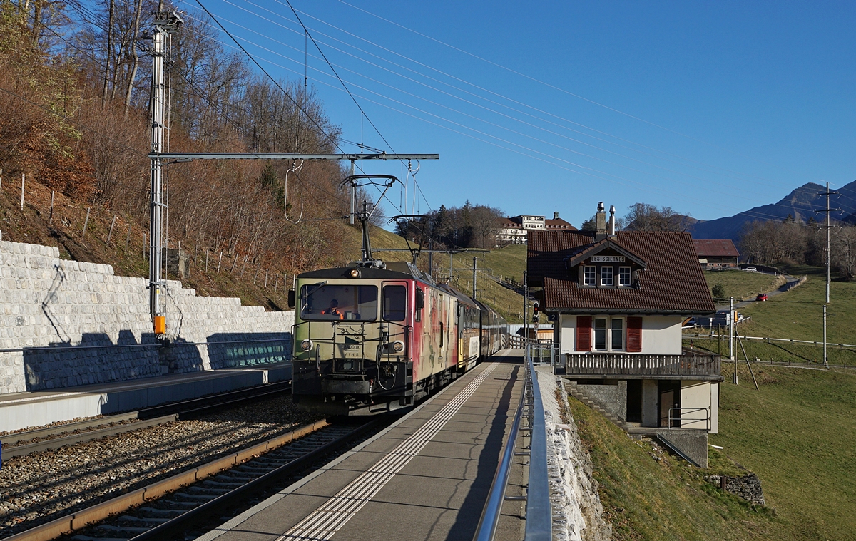 Die MOB GDe 4/4 6006  Aigle les Murailles  (ex GFM/TPF GDe 4/4 102) fährt mit dem MOB Golden Pass Panoramic PE 2111 durch den Bahnhof von Les Sciernes. Der Zug besteht aus den Wagen Bs 222, Bs 234, Bs 233 und BDS 224, wobei der Schlusswagen entgegen seiner Bezeichnung über 1. Klasse Sitze verfügt.

26. November 2020 