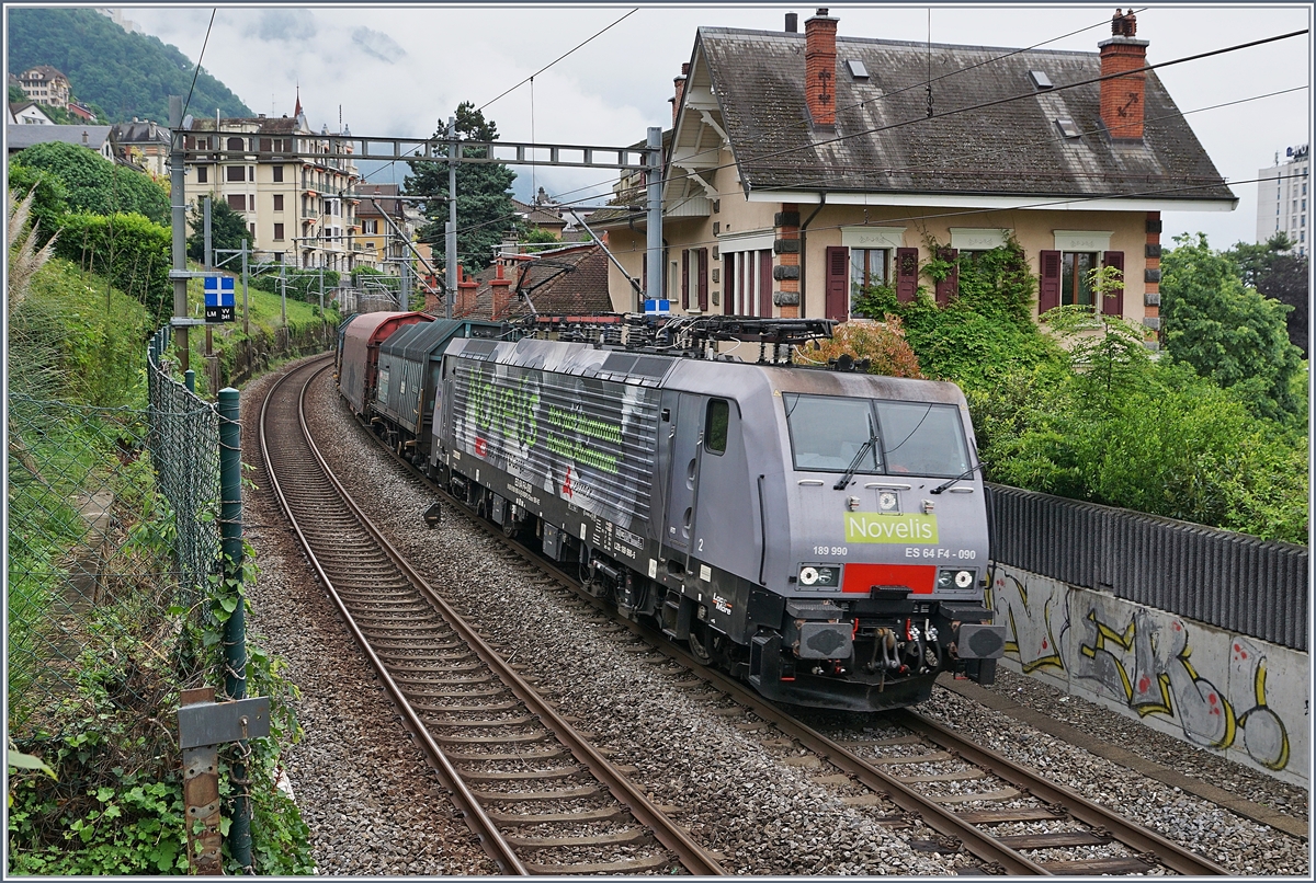Die SBB NOVELIS  Re  189 990-5  Göttingen  (ES 64-F4-90 / UIC 91 80 6189 990-5 D-Dispo Classe 189VE) fährt mit ihrem hier nicht zu sehenden, recht langen, gemischten Novelis Zug auf dem Weg von Sierre nach Göttingen kurz nach Villeneuve in Richtung Lausanne.

15. Mai 2020