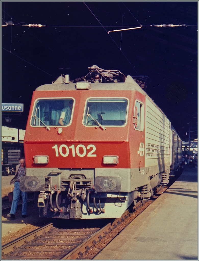 Die SBB Re 4/4 IV 10102 mit einem internationalen Schnellzuug von Milano nach Genève beim Halt in Lausanne. 
Sept. 1985