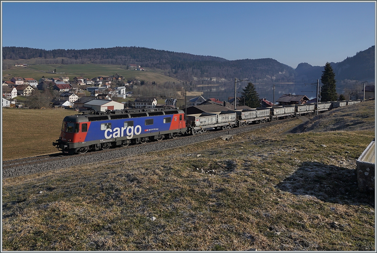 Die SBB Re 6/6 11610 (Re 620 010-9)  Spreitenbach  bringt etliche leere Fans-u Wagen als Güterzug 69701 von Lausanne-Triage nach Le Brassus und konnte hier bei Les Charbonnières mit dem Hintergrund des Lac de Brenet fotografiert werden. 

24. März 2022