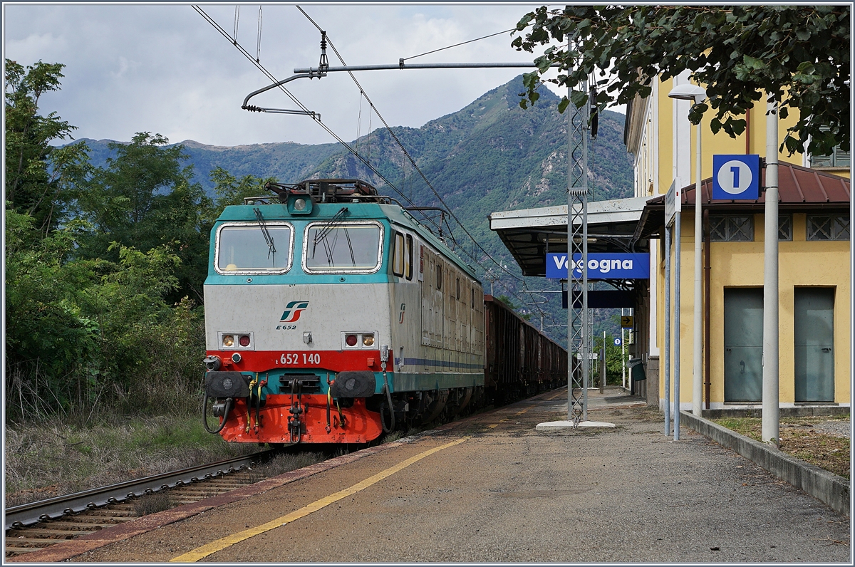 E 652 140 f�hrt mit einem G�terzug aus Eaos (oder �hnlichen Wagen) durch den Bahnhof von Vogogno. Der Bahnhof verf�gt �ber dieses Gleis der Stecke Domodossola - Novara und etwas zwanzig Meter weiter Westlich �ber Gleise der Doppelspur Domodossola - Milano. Die beiden Strecken sind erst in Premosello verkn�pft und verlaufen etliche Kilometer mehr oder weniger Parallel. 18. Sept. 2017