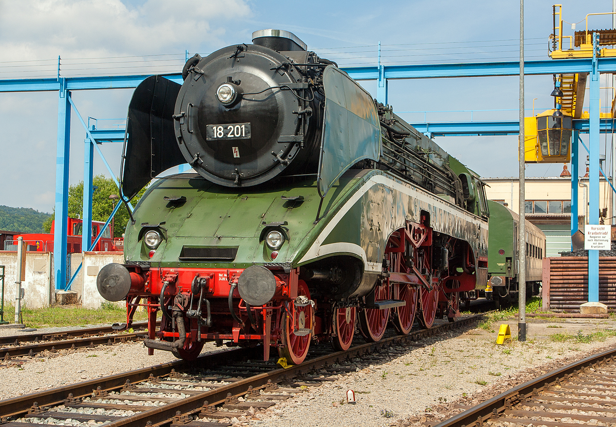 Einfach eine Schönheit....
Die 18 201 (ex DR 18 201 ex DR 02 0201-0) der Dampf Plus steht am 24.08.2013 im Dampflokwerk Meiningen (DLW).

Sie ist, mit einer Höchstgeschwindigkeit von 182,5 km/h, die schnellste betriebsfähige Dampflokomotive der Welt. Sie hat mit 2,3 m Durchmesser mächtig große Treibräder. Zudem ist sie ein Unikat, diese Lok gab und gibt es nur einmal auf der Welt.

Die Schnellzuglokomotive mit der Nummer 18 201 der Deutschen Reichsbahn entstand 1960 bis 1961 im Reichsbahnausbesserungswerk Meiningen aus Teilen der Henschel-Wegmann-Zug-Lokomotive 61 002, dem Schlepptender der 44 468 und Teilen der H 45 024 und einer Lokomotive der DR-Baureihe 41. Sie war eine der schnellsten betriebsfähigen Dampflokomotiven der Welt.

Die Motive für den Umbau waren zum einen, dass die bereits seit Jahren abgestellte 61 002 als Einzelstück kaum im Plandienst zu gebrauchen war, zum anderen, dass die VES-M Halle dringend Schnellfahrlokomotiven für eine Geschwindigkeit von mindestens 160 km/h benötigte, um Probefahrten mit für den Export bestimmten Reisezugwagen der einheimischen Waggonbau-Industrie durchzuführen. Mit ihren 2.300 mm großen Treibrädern bot sich die 1939 bei Henschel & Sohn gebaute 61 002 für einen solchen Umbau an. Der Umbau war von dem Leiter der Fahrzeugversuchsanstalt Halle Max Baumberg initiiert worden.

Von der 61 002 wurde der vordere Rahmenteil (Barrenrahmen) und das Trieb- und Fahrwerk bis zur dritten Kuppelachse übernommen. Der Rahmen für das hintere Bisselgestell, der hintere Kuppelkasten sowie die Außenzylinder stammten von der misslungenen Hochdrucklokomotive H 45 024. Der hintere Rahmen wurde in Anlehnung an den Rahmen der H 45 024 neu als Blechrahmen konstruiert und an den vorderen Barrenrahmen angeschweißt. Der Rahmen der H 45 024 konnte nicht verwendet werden, da dessen Wangenstärke von 100 mm nicht zu den 80 mm des Barrenrahmens der 61 002 passte.

Der Innenzylinder wurde durch eine Neukonstruktion ersetzt. Der Ersatz der Zylinder war notwendig, da die ursprüngliche Dampfmaschine der Baureihe 61 einen Druck von 20 bar erforderte, passende Kessel aber wegen Material- und Unterhaltungsproblemen keine ausreichende Lebensdauer erreichten. Als Dampferzeuger kam der Neubaukessel 39 E zum Einsatz, welcher auch in den Baureihen 03, 22 und 41 Verwendung fand. Der Tender war zuvor mit der 44 468 gelaufen. Die Lok erhielt auch, wie zu dieser Zeit üblich, einen Giesl-Ejektor.

Um die Maschine wieder unter Dampf zu setzen, gründeten der Unternehmer Christian Goldschagg und der Musiker Axel Zwingenberger zunächst die Initiative Rettet die 18 201 und anschließend die Dampf-Plus GmbH. Mit dem Geld dieser Firma wurde die Lok im Dampflokwerk Meiningen vollständig aufgearbeitet und am 4. April 2002 den Investoren übergeben. Dampf-Plus hatte als Geldgeber in diesem Zusammenhang mit dem DB Museum einen Kooperationsvertrag geschlossen, um die Investitionssumme durch Nutzungsrechte an der Lok mittels Vermarktungskonzepten gewinnbringend wieder einzuspielen und am Erhalt der 18 201 maßgeblich mitzuwirken. In der Folge kam es zu einem Streit über die Wahrung der Vertragsinhalte mit der Deutschen Bahn AG, wobei es auch darum ging, dass aus Sicherheitsgründen nur DB-Stammpersonal die Lokomotive bedienen durfte. Im März 2004 wurden die Kooperationsverträge endgültig aufgehoben, wobei die DB weiterhin auf ihr Recht der Personalgestellung pochte. Ab dem 28. Februar 2004 war Dampf-Plus Eigentümer der Lokomotive und versuchte in der Folge, die Lokomotive wieder zu verkaufen, um die Verluste des Unternehmens zu kompensieren.

Zwischen dem 30. April 2002 und dem 10. Juli 2005 war die traditionell in Grün lackierte Maschine in einer roten Sonderlackierung RAL 3003 (Rubinrot) unterwegs, die der Modellbahnhersteller Roco für diesen Zeitraum gesponsert hatte. Nach dieser Vermarktungskampagne erhielt 18 201 eine chromoxidgrüne Färbung RAL 6020.

Nach der Aufarbeitung war die unter Denkmalschutz stehende Lokomotive bis zum 30. April 2012 im Ringlokschuppen des ehemaligen Bahnbetriebswerks Nossen untergebracht und wurde danach in Wittenberg stationiert.

Von 2010 bis 2015 war sie durch die Deutsche Museums-Eisenbahn im nationalen Fahrzeugeinstellungsregister angemeldet. Seit 2015 ist die Lokomotive durch die Sonderzugveranstaltungen in Chemnitz registriert. Im Jahr 2005 ging die Lokomotive in das Privateigentum von Christian Goldschagg über, nachdem die Dampf-Plus GmbH die eigenständige Vermarktung aus wirtschaftlichen Gründen aufgeben musste. Goldschagg hat nach der Übernahme alle Mitarbeiter der Dampf-Plus GmbH entlassen, um die Lokomotive direkt über seinen Münchener Mietservice zu vermarkten.

Ende 2018 liefen bei der denkmalgeschützten Lok 18 201 sämtliche Fristen an Fahrwerk und Kessel nach acht Jahren seit der letzten Hauptuntersuchung aus. Am 1. September fand noch eine große Abschiedsfahrt statt. Die Lokomotive wurde zunächst unzugänglich in einem Lokschuppen Wittenberg konserviert abgestellt. Am 14. August 2019 wurde die 18 201 wegen Geschäftsaufgabe der Dampf-Plus GmbH an die WFL GmbH & Co. KG, Potsdam verkauft. Der neue Eigentümer WFL hat im November 2019 die Lokomotive in das AW Neustrelitz zur Erledigung von Teilgewerken unter anderem an der Bremsanlagen von Lok und Tender im Rahmen der notwendigen gesetzlichen Hauptuntersuchung zur Wiederinbetriebnahme überführen lassen. Im September 2020 kehrte sie aus dem AW Neustrelitz in ihr Heimat-BW Nossen zurück, wo nun die weiteren Arbeiten der Hauptuntersuchung zur Erlangung der neuen Zulassung im Streckendienst durchgeführt werden. Nach erfolgreicher Zulassung für den Betriebsdienst steht die Lokomotive für Sonderfahrten wieder zur Verfügung.

TECHNISCHE DATEN:
Spurweite: 1.435 mm (Normalspur)
Achsformel:  2’C1’
Gattung:  S 36.20
Länge über Puffer: 25.145 mm
Leergewicht: 102,5 t
Dienstgewicht: 113,6 t
Dienstgewicht mit Tender: 186,8 t (mit vollen Vorräten)
Höchstgeschwindigkeit: 182,5 km/h
Indizierte Leistung: 1.581 kW
Anfahrzugkraft: 	ca. 147 kN
Treibraddurchmesser: 	2.300 mm
Laufraddurchmesser vorn: 1.100 mm
Laufraddurchmesser hinten: 1.250 mm
Zylinderanzahl: 	3
Zylinderdurchmesser: 	520 mm
Kolbenhub: 660 mm
Kesselüberdruck: 16,3 bar
Anzahl der Heizrohre: 	112
Anzahl der Rauchrohre: 36
Heizrohrlänge: 5.700 mm
Rostfläche: 4,23 m²
Strahlungsheizfläche: 	21,3 m²
Rohrheizfläche: 	185 m²
Überhitzerfläche: 83,80 m²
Verdampfungsheizfläche: 206,30 m²
Tender: 2'2' T 34 + Zusatztender
Wasservorrat:  34,0 m³
Brennstoffvorrat: 13,5 m³  (Schwer-Öl)
Zugheizung: Dampf 
