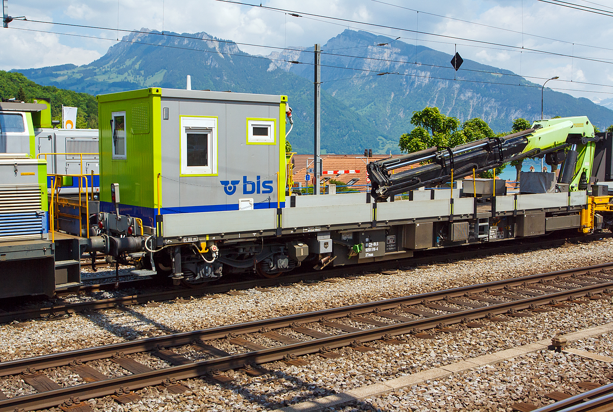 Erhaltungsfahrzeug EHF bzw. der selbstfahrende Dienstwagen XTmas 516 mit Palfinger Kran 100002 D 100mt  (99 85 92 59 516-4 CH-BLS) abgestellt am 28.05.2012 beim Bahnhof Spiez (aufgenommen aus einfahrendem Zug).

Für die Durchführung der Arbeiten innerhalb der Erhaltungsabschnitte werden Erhaltungsfahrzeuge (EHF)  mit modularen, den jeweiligen Anforderungen entsprechenden, Aufbauten und Ausrüstungen eingesetzt.
Im Laufe des Jahres 2006 erhielt die BLS insgesamt 13 Erhaltungsfahrzeuge von der Firma SCHÖRLING-BROCK GmbH in Gehrden bei Hannover. Von den13 Fahrzeugen besitzen 9 einen hydrostatischen Antrieb, der den Eigenbetrieb bis zu einer Geschwindigkeit von 60 km/h erlaubt, der geschleppte Betrieb ist bis 100 km/h zugelassen. Die UIC-Konformität der Konstruktion ist gegeben. Die Fahrzeuge sind im Konzept eines 60“-Containerwagens gestaltet mit unterschiedlichen Aufbauten und einem Leergewicht zwischen 21 t für einen nicht angetriebenen und 47 t für diesen angetriebenen Tragwagen mit aufgebautem 100mt-Kran und 14 Tonnen Gegengewicht. Bei dem einheitlichen Gesamtgewicht aller Wagen von 72 t ergeben sich somit für Baufahrzeuge beachtliche Zuladungskapazitäten.

Die geringe Ladehöhe von 1.140 mm sowie die maximale Pufferhöhe von 990 mm ergeben mit der damit einhergehenden Überlademöglichkeit für Langgut vielseitige Anwendungsmöglichkeiten.
Die Bremsanlage wird generell mit einer Federspeicherbremse ergänzt. Bei den angetriebenen Fahrzeugen ist neben der Lokbremse auch noch eine Anhängerbremse vorhanden.

Technische Daten Grundfahrzeug mit Antrieb:
Angetrieben werden jeweils die inneren Achsen der Drehgestelle mittels Hydrostat und Getriebe von einem 210 kW starken Deutz-Motor mit Partikelfilter der Fa. Hug Engeneering AG.
Der Energiebedarf der Aufbauten oder von Werkzeugen neben dem Fahrzeug wird von einem hydrostatisch angesteuerten Generator mit 50 bzw. 60 kVA gewährleistet. Um eine möglichst tief liegende Ladefläche verwirklichen zu können, kommen vom UIC-Standarddrehgestell Y31 abgeleitete Drehgestelle der Bauart Y31Lssif-D-(AK) von der Firma Eisenbahn Laufwerke Halle (ELH) zum Einsatz, welche sich bei einem Neuraddurchmesser von 760mm durch eine tief liegende Abstützebene für das Untergestell auszeichnen
Für Start, Beleuchtung und Gewährleistung von Notfunktionen über eine EPumpe stehen 24 V/630 Ah Batteriekapazität zur Verfügung.
Als Steuerungselektronik kommen fahrzeugtaugliche Digsy Outdoor-Komponenten der Firma Intercontrol mit einer Funkfernsteuerung der Firma Theimeg zum Einsatz. Diese Kombination ist bereits auf Baudienstfahrzeugen der Deutschen Bahn AG im Einsatz.
Neben den Kranaufbauten werden variabel aufsetzbare Aufbauten wie Kabelrollböcke, Arbeitsbühnen sowie Mannschafts- und Magazincontainer mit 10 Fuß und 20 Fuß Länge eingesetzt.
Fixe und abnehmbare Aufbauten sind als Mannschaftsraum und WC ausgebildet.
Zum Einsatz der Funkfernbedienung mit V-Max 80 km/h sind diese mit Notbremsventil ausgeführt. Die Steuerung der Erhaltungsfahrzeuge erfolgt im Fahrbetrieb generell mit einer Theimeg-Funkfernsteuerung. Im Kranbetrieb erfolgt die Versetzfahrt mit bis zu 9,5 km/h über die Kranfernbedienung. Als Rückfallebene dient eine Kabelfernbedienung (bis 40 km/h).

Bei der BLS werden folgende Ausbildungen von angetriebenen Erhaltungsfahrzeugen (EHF) eingesetzt:
3 Fahrzeuge für Mannschaft, Material und Werkzeug mit ca. 8,0 m freier Ladeflächenlänge, asymmetrisch aufgebautem Kran (ca. 14 mt) für die Manipulation von Paletten und leichten Gütern sowie die Unterstützung von Arbeitsprozessen.
5 Fahrzeuge mit Kran (20 mt) bzw. dreiteiliger Arbeitsbühne und Fahrleitungsdrückanlage. 2 Kräne sind auch mit Arbeitskorb für die Fahrleitungsmontage ausgerüstet.
1 Fahrzeug (dieses hier) mit großem Kran (ca.100 mt) mit dem für die Störungsintervention zusammen mit einem anderen Fahrzeug auch die Zungenvorrichtungen der Schnellfahrweichen mit bis zu 64 m Länge und Herzstücke mit bis zu 7,5 t Gewicht und 22,5 m Länge transportiert und manipuliert werden können
Fünf weitere von der BLS AG selbstgebaute Fahrzeuge kamen 2012 und 2013 (XTmas 521-525)  hinzu. 2x mit Kran PKR 200 C (20 mt), 1x mit PKR 480 D (48 mt) und 2x mit Kran PK 29002 C (29 mt). Diese Fahrzeuge haben ein Deutz-Dieselmotor vom Typ TCD 7.8 L6 mit 230 kW Leistung.

TECHNISCHE DATEN:
Spurweite: 1.435 mm (Normalspur)
Achsfolge: (1Ao)  (Ao1)
Wagenlänge über Puffer: 19.640 mm
Drehzapfenabstand: 14.200 mm
Achsstand im Drehgestell: 1.800 m
Bruttogewicht aller dargestellten Fahrzeuge:  72 t
Eigengewicht  (XTmas 516): 54.5 t
Ladegewicht  (XTmas 516):  17.5 t
Ladelänge:  18.300 mm
Ladebreite:  2.760 mm
Ladehöhe:  1.150 mm
Pufferhöhe über SOK (Neuzustand ohne Beladung): 990 mm
Drehgestelle: Y31Lssif-D-(AK)
Raddurchmesser neu / abgenutzt:  760 / 700 mm
Motorleistung: 210 kW
Dieselmotor Typ:  Deutz BF 6M 1013 FC EURO III
Partikelfilter: mobiclean S / Hug Engeneering AG
Antriebsart: hydrostatisch, jeweils auf die innenliegende Achse der Drehgestelle
Bremsanlage: direkte Druckluftbremse,indirekte Druckluftbremse DK-GP-A, Hydrostatische verschleiß freie Bremse, Feststellbremse als Federspeicher (separat ansteuerbar).
Feststellbremse Federspeicher:  bis 40 ‰
Maximale Geschwindigkeit Eigenantrieb:  60 km/h
Maximale Geschwindigkeit geschleppt: 100 km/h
Maximale Geschwindigkeit Kranbetrieb:  9,5 km/h
