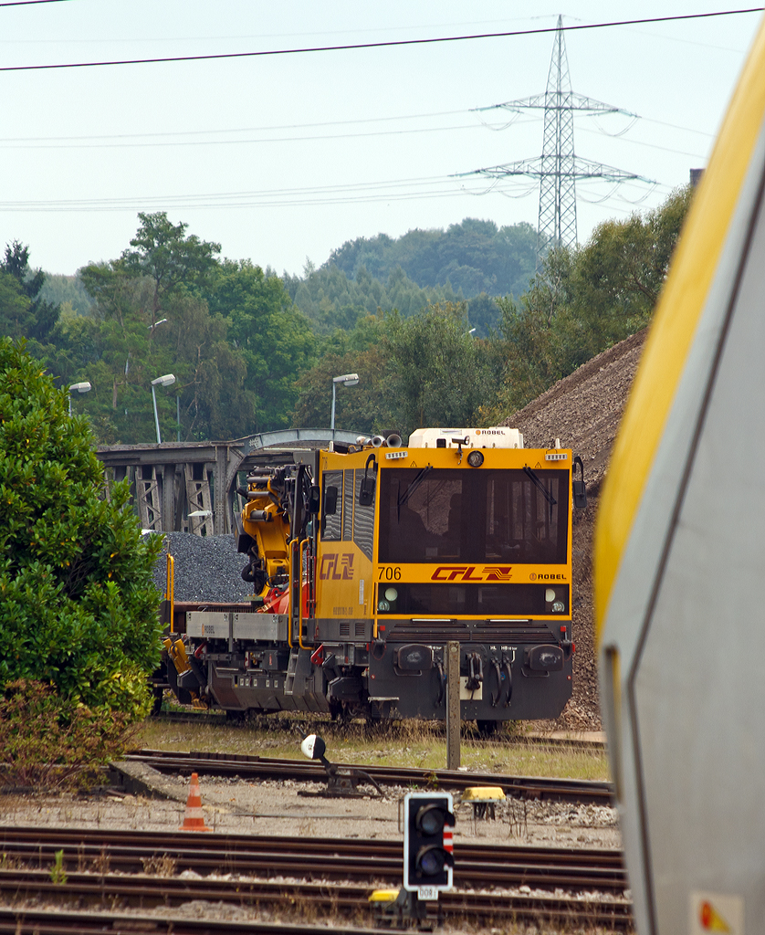 
Etwas versteckt abgestellt ist der CFL Robel IIF 706 (99 82 9210 706-2 L CFL IF) am 14.09.2014 beim Bahnhof Ettelbrück (Ettelbréck). 

Das Interventions- und Instandhaltungsfahrzeug (IIF) draisine - Robel 54.22 wurde 2010 von ROBEL Bahnbaumaschinen gebaut. Die deutsche Bezeichnung wäre Gleisarbeitsfahrzeug BAMOWAG 54.22 

CFL (Société Nationale des Chemins de fer Luxembourgeois, die luxemburgische Staatsbahn) Série /Baureihe: 700
Anzahl bei CFL :  12
Hersteller:  ROBEL Bahnbaumaschinen
Spurweite: 1.435 mm Zahl der Radachsen : 2 Achsformel: B
Länge über Puffer:  15.100 mm
Eigengewicht: 36,5 t
Leistung: 500 KW
Höchstgeschwindigkeit:  100 km/h 
Anmerkungen: Ausgestattet mit Kran Palfinger PR 220D