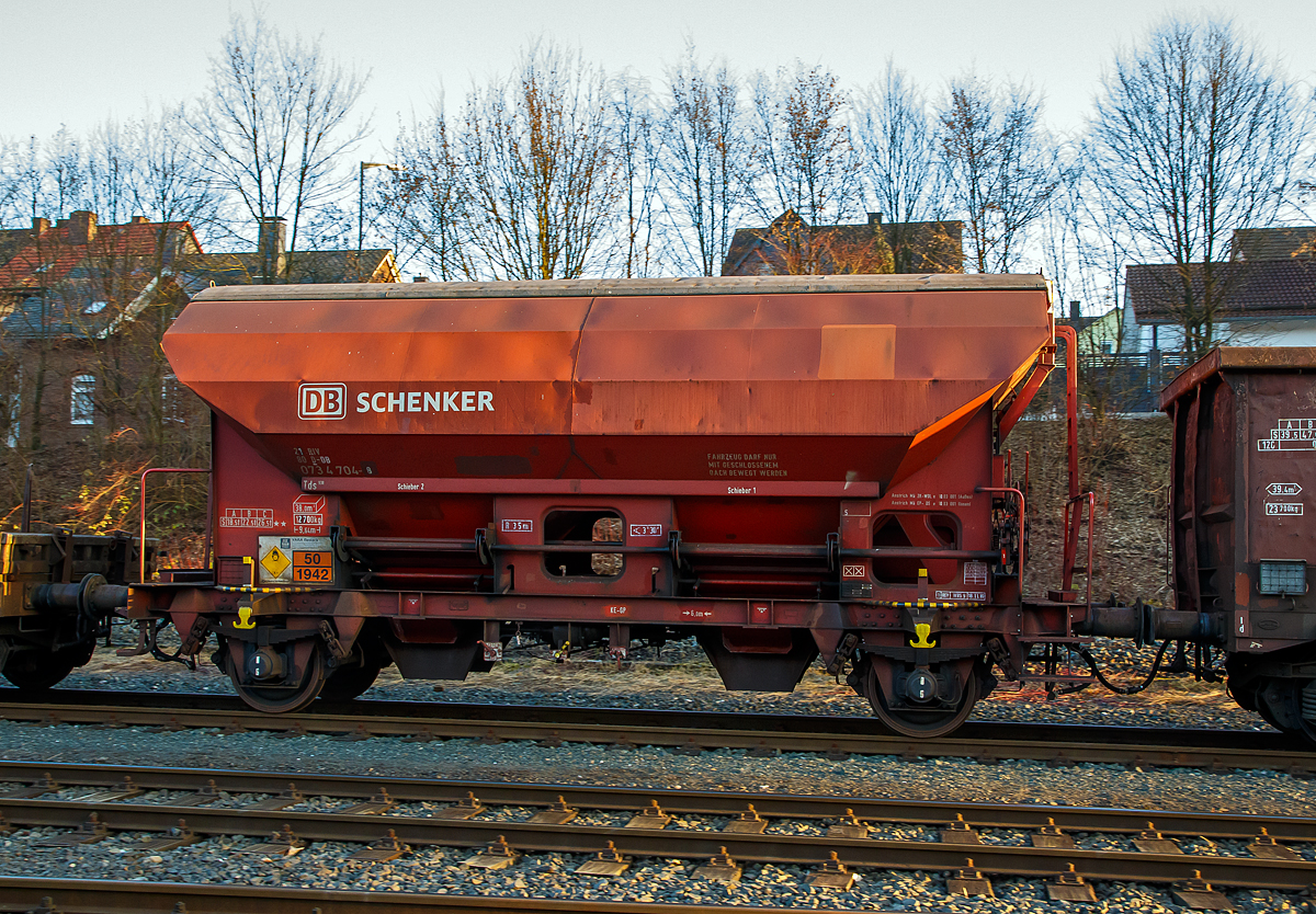 Gedeckter Sch�ttgutwagen mit dosierbarer Schwerkraftentladung und zwei Rads�tzen 21 80 0734 704-8 D-DB, der Gattung Tds 938, der DB Cargo AG am 14.02.2017 in Herdorf, im Zugverband auf dem Rbf der KSW.

Der Wagen tr�gt au�erdem einen Aufkleber der Firma YARA Rostock, das zum norwegischen Konzern Yara International geh�rt. Yara ist ein Hersteller und Anbieter von Chemikalien und Industriegasen wie D�nger, Harnstoff, Nitraten und Ammoniak. Das Unternehmen entstand 2004 durch Abtrennung vom Unternehmen Hydro Agri, einem Firmenbereich von Norsk Hydro.

Die Wagen besitzen eine gleisseitige, dosierbare Entladeeinrichtung. Ein Innenanstrich erh�ht bei den meisten der Fahrzeuge den Gebrauchswert, insbesondere durch den Schutz vor Verunreinigungen, M�glichkeiten des Transportes von Lebensmitteln, g�nstigeres Entladeverhalten (Rutschverhalten) bei schwer flie�enden G�tern sowie durch verbesserten Korrosionsschutz bei aggressiven Ladeg�tern.

Der Wagen ist f�r den Transport von n�sseempfindlichen Sch�ttg�tern aller Art, wie z. B. Salze und D�ngemittel, vorgesehen. Sie besitzen eine gleisseitige, dosierbare Entladeeinrichtung. Ein Innenanstrich erh�ht bei den meisten der Fahrzeuge den Gebrauchswert, insbesondere durch den Schutz vor Verunreinigungen, M�glichkeiten des Transportes von Lebensmitteln, g�nstigeres Entladeverhalten (Rutschverhalten) bei schwer flie�enden G�tern sowie durch verbesserten Korrosionsschutz bei aggressiven Ladeg�tern. Der Transport grobk�rniger oder kantiger, schwerer G�ter (z. B. Kies, Schlacke, Schotter) ist wegen einer m�glichen Besch�digung der Innenbeschichtung nicht zul�ssig.

Das Untergestell und der Wagenkasten sind als Schwei�konstruktion unter Verwendung von Walzprofilen und Blechen hergestellt. Beide Teile sind miteinander verschwei�t. Der Wagen besitzt zwei B�hnen, die von beiden Seiten zug�nglich sind. Beide B�hnen sind mit einer Sprossenleiter versehen. Die Arbeitsb�hne ist mit Handhebeln zur Bet�tigung der W�lbschieber, mit dem Handrad zur �ffnung des Daches und teilweise mit einer Feststellbremse und Notbremshahn ausger�stet. Der Neigungsgrad des trichterf�rmigen Wagenkastens erm�glicht eine restlose selbstt�tige Entladung. Die Entladung des Wagens erfolgt �ber W�lbschieber. Der Wagen ist mit einem einschaligen Hubschwenkdach ausger�stet. Das Dach wird vor dem Schwenken angehoben und dann seitlich abgeschwenkt, wobei die gesamte Breite der Belade�ffnung freigegeben wird. Im geschlossenen Zustand ist das Dach gegen unbeabsichtigtes Verschwenken gesichert.

In diesen Wagen wird Ammoniumnitrat (Gefahrgutnummer 50/1942) zur Sprengstoff Herstellung zur Fa. Dynamit Nobel Defence nach Burbach-W�rgendorf gefahren (hier ist er leer).  Ammoniumnitrat ist der Stoff  von dem ca. 2.750 Tonnen im Hafen von Beirut am 4. August 2020 explodierten und zur der bekannten gewaltigen Explosionskatastrophe f�hrten. 

TECHNISCHE DATEN:
Spurweite: 1.435 mm
Achsanzahl: 2
L�nge �ber Puffer: 9.640 mm
Achsabstand: 6.000 mm
Laufraddurchmesser: 1.000 mm (neu)
Wagenh�he: 4.198mm
Gr��e der Belade�ffnung L�nge x Breite: 8.000 x 1.200 mm
Laderaum: 38 m�
Eigengewicht: 12.700 kg
H�chstgeschwindigkeit: 100 km/h (beladen) / 120 km/h (leer)
Maximales Ladegewicht: 26,5 t  ab Streckenklasse C
Kleinster bef. Gleisbogenradius: 35 m
Bauart der Bremse: KE-GP
Intern. Verwendungsf�higkeit: RIV