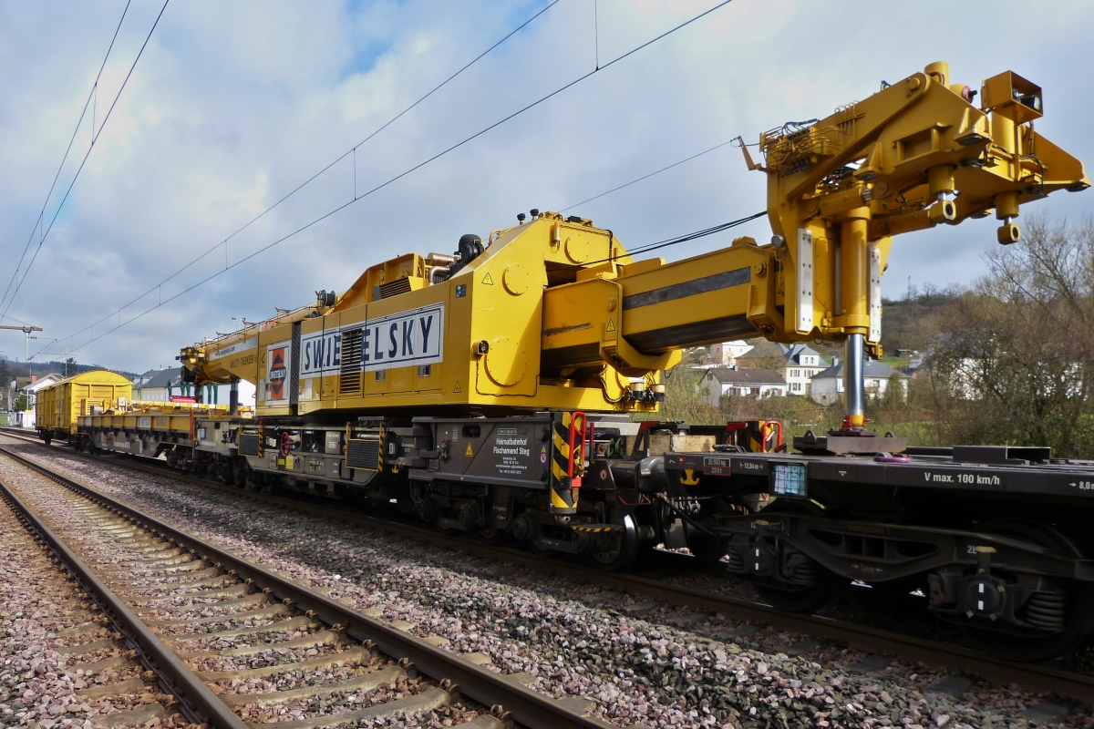 Gleisbauschienenkran KRC 1600, schweres Nebenfahrzeug im Transportzug eingereiht, (D-SWIE 99 80 9419 011-8), Eigengewicht 128 t, Max 100 km/h, (bei Selbstfahrt max 19 km/h), Bj. 2013, Bau Nr: MT 2011170177, steht zum Wechseln von 3 Weichen in der N�he des Bahnhofs von Wilwerwiltz bereit. 12.04.2021