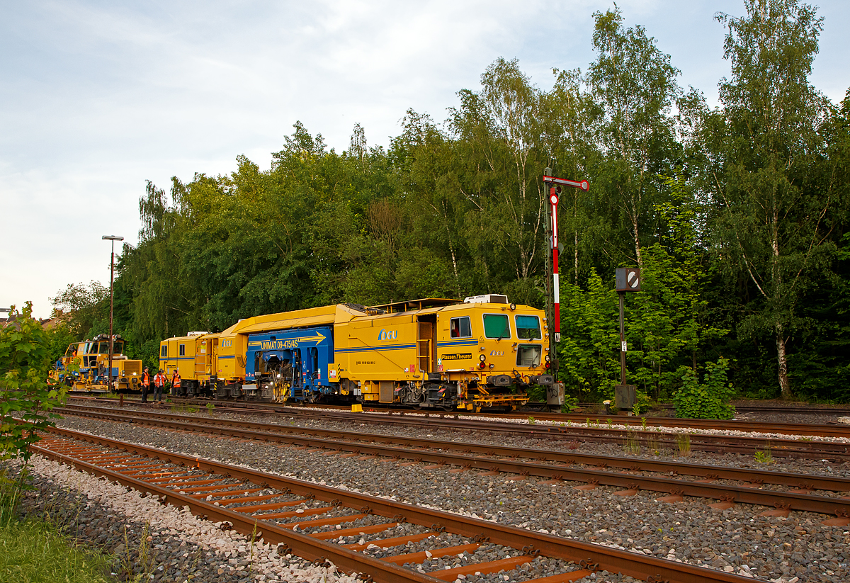 Im Einsatz am Gleis 4 im Bahnhof Herdorf am Abend des 11.06.2021: Die Plasser & Theurer Universalstopfmaschine UNIMAT 09-475/4S (Kombinierte Gleis- und Weichenstopfmaschine), Schweres Nebenfahrzeug Nr. D-DGU 99 80 9424 001-2 und dahinter die Plasser & Theurer Schotterverteil- und Planiermaschine SSP 110 SW, Schweres Nebenfahrzeug Nr. D-DGU 99 80 9425 068-0, ex 97 16 46 516 18-9 D-DGU (ex Hering Gleisbau, ex Volker-Rail). Beide Maschinen gehören der der DGU - Deutsche Gleisbau Union aus Koblenz.
