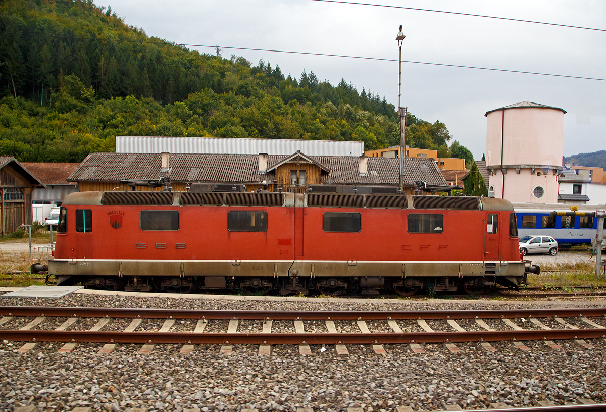 Leider der Beschilderung beraubt...
Die ehemalige SBB Re  6/6 11601  WOLHUSEN , später Re 620 001, eine der beiden Prototypen mit zweiteiligen Kasten, ist am 09.09.2021 abgestellt in Sissach. Aufgenommen aus dem Zug durch die Scheibe. 

Die SBB Re 6/6 Prototypen wurde 1972 von SLM in Winterthur (Schweizerische Lokomotiv- und Maschinenfabrik) gebaut. Im Herbst 2019 wurde bekannt, dass die zweiteiligen Prototypen 11601 und 11602 an eine Privatperson im Umfeld des Vereins Swisstrain verkauft wurden. Es ist geplant, dass die 11601 revidiert und wieder fahrtüchtig gemacht werden soll, die 11602 sollals Ersatzteilspender genutzt werden. Im Oktober 2019 wurde die 11601 deshalb von Bellinzona nach Sissach überführt.

Die Re 6/6, nach neuem Bezeichnungsschema Re 620, sind sechsachsige, elektrische Lokomotiven der Schweizerischen Bundesbahnen (SBB), die als Ersatz für die Ae 6/6 im schweren Dienst am Gotthard angeschafft wurden. Aus den Anforderungen an die Baureihe ergab sich für die Traktion die Notwendigkeit von sechs Triebachsen. Um dennoch gute Kurvenlaufeigenschaften mit niedrigem Verschleiß zu erreichen, wurden im Gegensatz zur Ae 6/6 drei zweiachsige Drehgestelle eingebaut, wobei sich das mittlere stark seitlich bewegen kann. Für einen besseren Kurveneinlauf der nachlaufenden zwei Drehgestelle wurden zusätzlich zwischen den drei Drehgestellen elastische Querkupplungen angeordnet. Dabei basiert die Querkupplung auf dem Prinzip, welches ursprünglich für die Ge 6/6II der Rhätischen Bahn (RhB) entwickelt wurde. Zwei der vier Prototypen (11601 und 11602) erhielten wie die Ge 6/6II der RhB einen geteilten Lokkasten, wobei sich das Gelenk analog zur RhB Ge 6/6II nur vertikal bewegen kann, um sich Gefälleänderungen anzupassen.

Die bei den beiden anderen Prototypen gewählte weichere Sekundärabfederung des mittleren Drehgestells bewährte sich im Versuchsbetrieb, so dass bei der Serienproduktion der einteilige Kasten zur Ausführung kam. Die zwei Prototypen mit geteiltem Kasten wurden aber weiterhin im Regelbetrieb eingesetzt.

Das Design ist der Form der Re 4/4II angelehnt, ebenso die Bedienung und die herkömmliche Trafotechnik, welche bei der Re 6/6 zuletzt eingesetzt wurde. Bei der Re 6/6 sind allerdings zwei Transformatoren (Leistungstransformator und Regeltransformator) vorhanden, die sich im Lokomotivkasten zwischen den Drehgestellen befinden.

TECHNISCHE DATEN (Serie):
Gebaute Stückzahl:  4 Prototypen und 85 Serienmaschinen
Hersteller: 	SLM, BBC, SAAS
Baujahre: 	1972 (Prototypen), 1975–1980 (Serie)
Spurweite:  1.435 mm (Normalspur)
Achsfolge:  Bo'Bo'Bo'
Länge über Puffer: 19.310 mm
Drehzapfenabstände: 5.700 / 5.700 mm
Achsabstand in den Drehgestellen: 2.900 mm
Treibraddurchmesser: 	1.260 mm (neu)
Höhe: 3.932 mm
Breite: 2.950 mm
Dienstgewicht: 120 t
Anzahl der Fahrmotoren: 6
Stundenleistung an der Welle: 6 x 1.338 kW = 8.028 kW
Stundenleistung am Rad: 7.802 KW
Dauerleistung am Rad: 7.244 kW
Höchstgeschwindigkeit: 140 km/h
Getriebeübersetzung: 1: 2,636
Anfahrzugkraft: 395 kN
Stundenzugkraft: 267 kN
Dauerzugkraft: 235 kN
Elektrische Bremse: Nutzstrom
Stromsystem: 15 kV, 16,7 Hz ~
