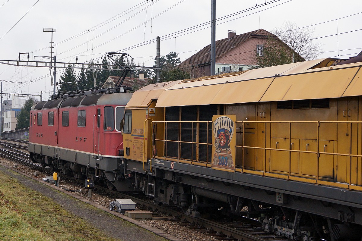 SBB: Güterzug mit der Re 6/6 11601  WOLHUSEN  beim Güterbahnhof Langenthal am 19. Januar 2015. Hier handelt es sich um einen Prototyp mit zweiteiligem Kasten. Von dieser Bauart existieren nur die 11601  WOLHUSEN  sowie die 11602  MORGES . In Langenthal wurde bei diesem Güterzug hinter der Re 6/6 eine Gleisbaumaschine von Scheuchzer eingereiht.  
Foto: Walter Ruetsch
