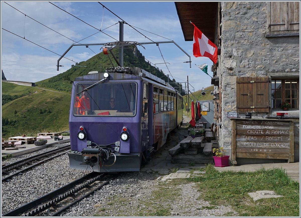Seit letztem Jahr ist die Buvette de Jaman an der gleichnamigen Station in der Saison von Donnerstag bis Sonntag wieder geöffnet. Und wie man sieht, können die rechts im Bild aufgelisteten Köstlichkeiten in unmittelbarer Tuchfühlung zur Rochers de Naye Bahn genossen werden. Ach ja, ein Zug ist ja auch noch zu sehen: Der Bhe 4/8 303 und ein weiterer Bhe 4/8 sind als Regionalzug 3360 vom Rochers de Naye Richtung Montreux unterwegs.
3. August 2017