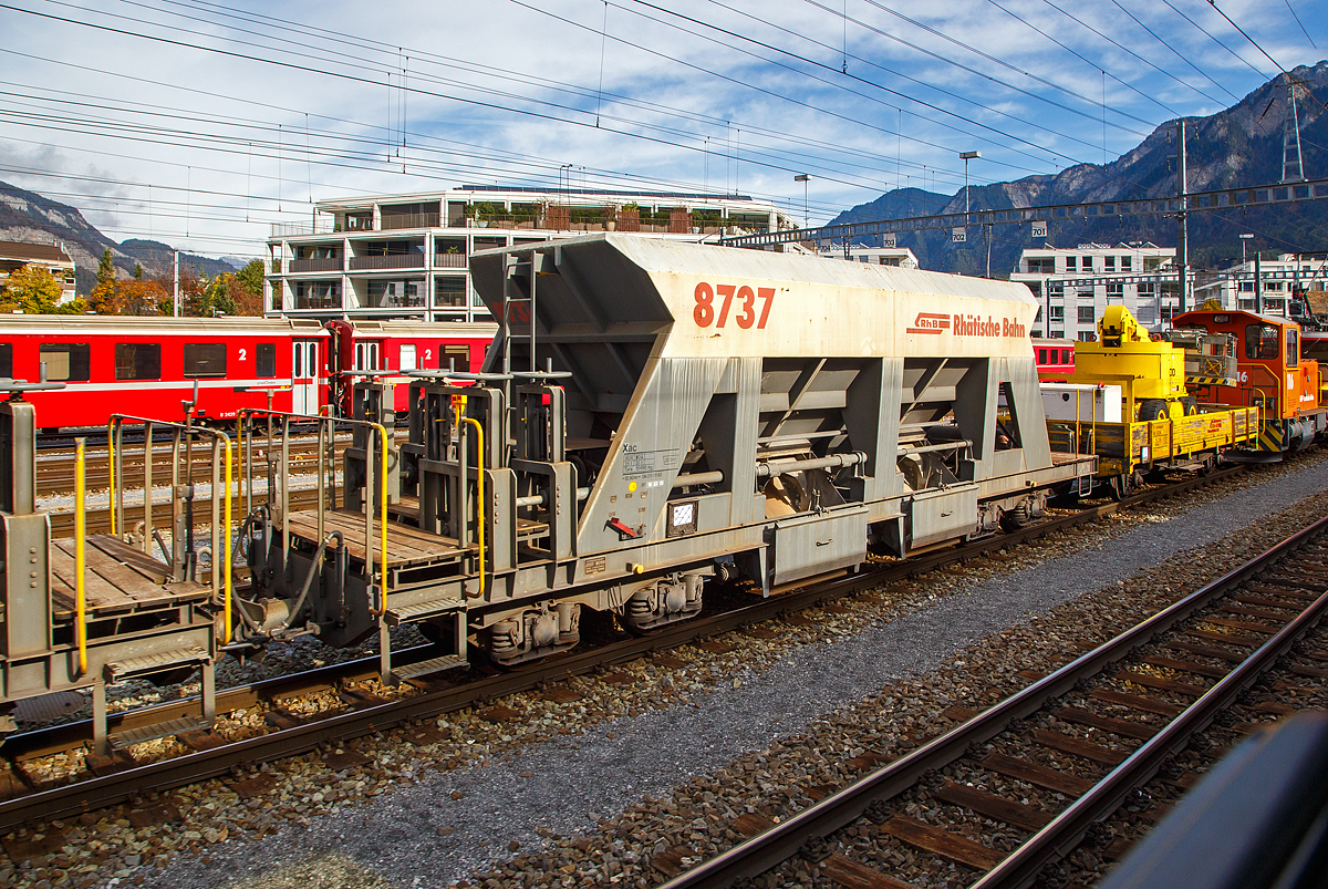 Vierachsiger Schmalspur Drehgestell-Schotterwagen (Schwerkraftentladewagen) Xac der Serie 8726 – 8742 (hier Xac 8737, ex Fac 8737)  eingereiht in einen Bauzug am 01.11.2019 im Rbf Chur (aufgenommen aus einem Zug Heraus). Diese Wagen wurden 1997 von der Firma Josef Meyer in Rheinfelden gebaut, sp�ter erfolgte ein Umbau zum Dienstwagen Xac 8737.

Mit den Schwerkraftentladewagen transportiert die RhB problemlos Ihre Sch�ttg�ter wie Kies, Sand etc. auf der Schiene durch Graub�nden. Ein rascher Verlad und Entlad spart Zeit und Geld und mit 33 – 34 Tonnen Ladung ist es eine gewichtige Alternative zum Stra�entransport.

TECHNISCHE DATEN:
Spurweite: 1.000 mm
L�nge �ber Puffer: 12.500 mm
Breite �ber Alles: 2.550 mm
H�he �ber SOK: 3.360 mm
Drehzapfenabstand: 7.000 mm 
Achsabstand im Drehgestell: 1.400 mm
Laufraddurchmesser: 750 mm (neu)
Breite der Entlade�ffnungen: 2 x 1.232 mm
Eigengewicht: 15.490 kg
Ladegewicht: max. 33 t
Ladevolumen: 22 m�
