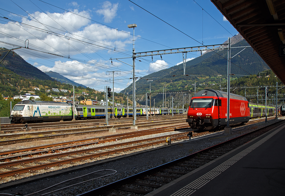 Zwei Geschwister aus der Lok-2000-Familie am 07.09.2021 im Bahnhof Brig:
Hinten links die BLS Werbelok Re 465 008-1  Allegra   (ex Niederhorn) mit Werbung Patenschaft für Berggemeinden und vorne rechts die SBB Re 460 027-6 „Joggeli“.