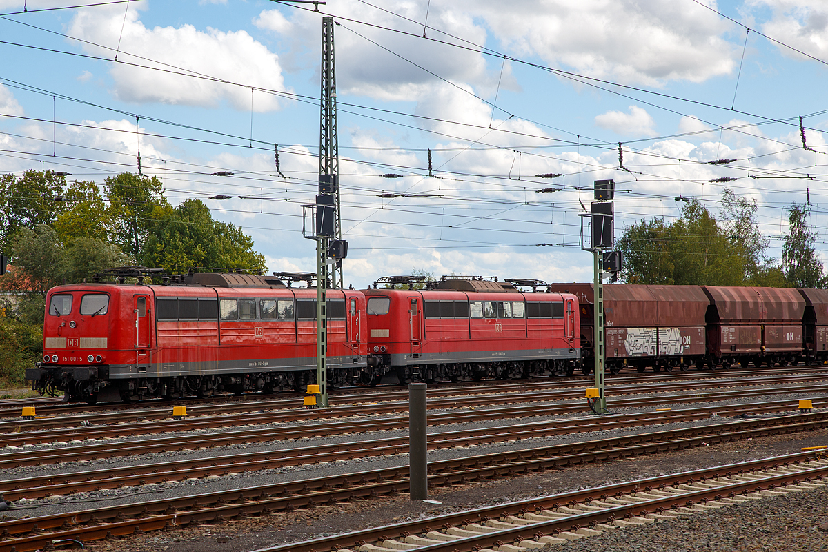 Zwei Loks der BR 151 der DB Cargo Deutschland AG mit einem Kohlezug sind am 02.10.2016 beim Bahnhof Friedberg (Hessen) abgestellt. Vorne ist die 151 001-5 (91 80 6151 001-5 D-DB), die allererste Lok der Baureihe 151, und dahinter die 151 036-1 (91 80 6151 036-1 D-DB).

Die 151 001-5 wurde 1972 von Krupp in Essen unter der Fabriknummer 5173 gebaut, der Elektrische Teil ist von AEG (Fabriknummer 8819). Als diese Vorserienlokomotive in Betrieb ging wurden auch noch Loks der Vorgänger-Baureihe 150 (E 50) gebaut.

Die 151 036-1 wurde 1974 von Krauss-Maffei AG in München unter der Fabriknummer  19655 gebaut, der Elektrische Teil ist von Siemens.

Schwerere und stärkere Güterzüge erforderten in den 1970er-Jahren eine neue Güterzuglokomotive. Um diese Ziele zu erreichen, wurde ein neues betriebliches Leistungsprogramm für den Güterzugdienst beschlossen, das die Beförderung von Schnellgüterzügen von 1000 t mit 120 km/h, Eilgüterzügen von 1200 t mit 100 km/h und Durchgangsgüterzügen von 2000 t mit 80 km/h auf Steigungen bis 5 ‰ vorsah. Weder die maximale Zugkraft noch die Höchstgeschwindigkeit der Baureihe 150 reichten hierfür aus. Zudem war seit ihrer Inbetriebnahme durch den Betriebsdienst bemängelt worden, dass die Zugkraft der Lokomotiven oberhalb von 80 km/h stark nachließ und bei hohen Lasten in diesem Geschwindigkeitsbereich häufig Fahrmotorschäden auftraten. Es wurde daher der Bau einer neuen Lokomotive für den schweren Güterverkehr gefordert. Mit der Entwicklung des elektrischen Teils beauftragte das BZA München die Firma AEG, mit dem Fahrzeugteil die Maschinenfabrik Krupp.

Weil die neuen Lokomotiven so schnell wie möglich zur Verfügung stehen sollte, konnte sie nicht völlig neu entwickelt werden, um alle Fortschritte der Technik hinsichtlich Lauftechnik und elektrischer Ausrüstung zu verwirklichen. Es wurde daher zunächst die Möglichkeit untersucht, die Baureihe 150 durch eine geänderte Getriebeübersetzung auf 120 km/h zu bringen und deren Fahrmotor EKB 760 in seiner thermischen Belastbarkeit durch eine Wicklungsisolierung der Klasse F statt B deutlich zu steigern. Diese Überlegungen wurden jedoch fallen gelassen, nachdem sich herausstellte, dass eine solchermaßen aufgewertete Baureihe 150 nur die Eilgüterzüge von 1200 t mit 100 km/h hätte befördern können.

Der Blick der Ingenieure von AEG und des BZA München fiel auf den ursprünglich von den Siemens-Schuckert-Werken entwickelten Fahrmotor WBM 372-22 der Baureihen 110, 139 und 140. Dieser Fahrmotor war deutlich leistungsfähiger, mit bereits über 4800 Stück in den genannten Baureihen im Einsatz und hatte sich außerordentlich gut bewährt. Es zeigte sich, dass eine mit diesem Fahrmotor ausgerüstete sechsachsige Lokomotive in der Lage wäre, das neue Betriebsprogramm voll zu erfüllen, wenn der Fahrmotor nicht wie bisher mit Materialien der Klasse B, sondern der Klasse F isoliert würde.

Da aber mit diesem Fahrmotor die Drehgestelle der Baureihe 150 nicht mehr verwendet werden konnten und infolge des leistungsfähigeren und schwereren neuen Transformators ein neuer Aufbau notwendig wurde, waren die Ingenieure in der Gestaltung dieser Teile frei und nahmen Anleihen bei der Baureihe 103, so bei der Verwendung eines Brückenrahmens und dem Aufbau des Maschinenraumes mit abnehmbaren Hauben. Im Übrigen wurden so weit wie möglich bewährte und bereits in großer Zahl vorhandene Komponenten aus den Baureihen 110/140 verwendet.

Am 21. November 1972 wurde als erste Lokomotive die 151 001 von AEG und Krupp ausgeliefert, es folgten elf weitere Vorserienlokomotiven, die ausgiebig erprobt wurden, bevor die Serienlieferung begann. Wie bereits bei den Einheitselektrolokomotiven wurden neben den Entwicklerfirmen AEG und Krupp die Firmen BBC und Siemens am Bau des elektrischen Teils und die Firmen Henschel und Krauss-Maffei am Bau des Fahrzeugteils der Serienlokomotiven beteiligt. Insgesamt wurden 170 Lokomotiven beschafft, die zunächst in Hagen und Nürnberg beheimatet waren.


Technische Daten der BR 151:
Spurweite: 1.435 mm
Achsformel: Co'Co'
Länge über Puffer: 19.490 mm
Gesamtradsatzstand: 13.660 mm
Drehgestell-Radsatzstand: 4.450 mm
Dienstgewicht: 118,0 t
Achslast:  19,7 t
Dauerleistung: 5.982 kW bei 95 km/h
Stundenleistung: 6.288 kW bei 92 km/h
Anfahrzugkraft: 395 kN
Dauerzugkraft: 232 kN
Höchstgeschwindigkeit: 120 km/h
Fahrmotoren: 6  (AEG WB372)
Fahrmotorgewicht: 2.850 kg (je Motor)  
Antrieb: Gummiringfeder-Antrieb
Getriebeübersetzung: 1:2,628
Elektrische Bremse: Thyristorgesteuerte Gleichstrom Widerstandsbremse
Max. Leistung elektr. Bremse: 6.660 KW

3000 t Züge kann sie bei 3 ‰ Steigung noch mit einer Dauergeschwindigkeit 75 km/h ziehen, bei 2000 t Zügen sind es 100 km/h.		 		
