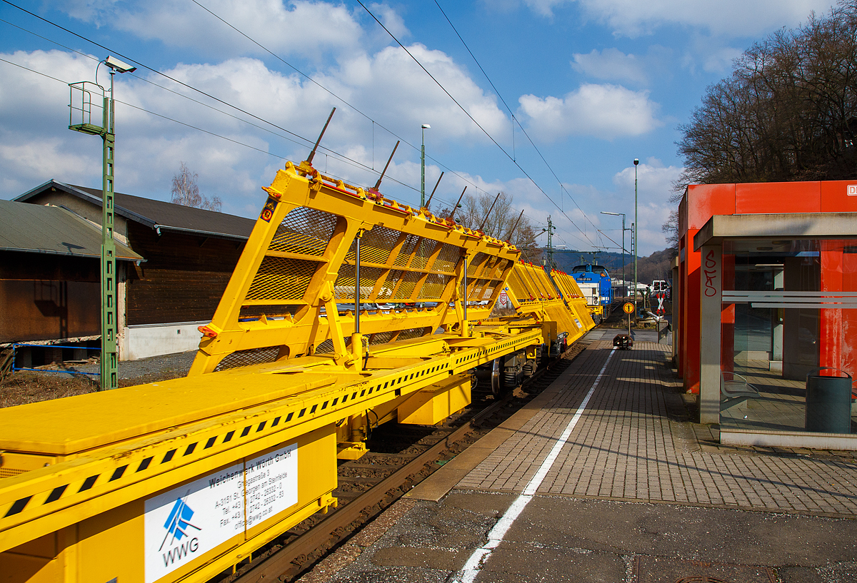 Zwei Matisa Weichentransportwagen WTM der WS-Logistik (Weichen- und Schienenlogistik) vom WWG - Weichenwerk W�rth GmbH (geh�rt zur voestalpine AG), UIC-Nr. 99 81 9358 0xx-x A-WWG, hier am 09.03.2016 bei einer Zugdurchfahrt im Bf. Scheuerfeld(Sieg), gezogen von der V 100-SP-010 (92 80 1203 146-6 D-SLG) der SLG Spitzke Logistik GmbH.

Mit den Weichentransportwagen WTW (Switch-Transport-Wagon) werden vormontierte Neu-Weichen direkt in den Einbauplatz der Baustelle transportiert. Auch der umgekehrte Weg ist umsetzbar. Das Konzept des WTW erlaubt den Transport gro�er Weichen zerlegt in ihren Segmenten unter Einhaltung des Lichtraumprofils. Der aufgesetzte Wagentisch wird hierzu in Schr�gstellung gebracht und arretiert. Diese Methode wird heutigen kurzen Sperrpausen und oftmals fehlenden Vormontagepl�tzen gerecht. Die Wagen kommen mit einem modernen Befestigungssystem zur Ladesicherung

TECHNISCHE DATEN der Wagen:
Hersteller: Matisa 
Spurweite: 1.435 mm (Normalspur)
L�nge �ber Puffer: 25.260 mm
Drehzapfenabstand: 19.300 mm
Achsabstand in den Drehgestellen: 1.800 mm
Laufraddurchmesser: 920 mm (neu)
Ladel�nge:  24.450 mm
Eigengewicht: 34.000 kg
Max. Zuladung: 30 t (ab Streckenklasse A)
Max. Geschwindigkeit: 100 km/h 
Kleinster befahrbarer Gleisbogen: R 150 m
Feststellbremse: Ja
