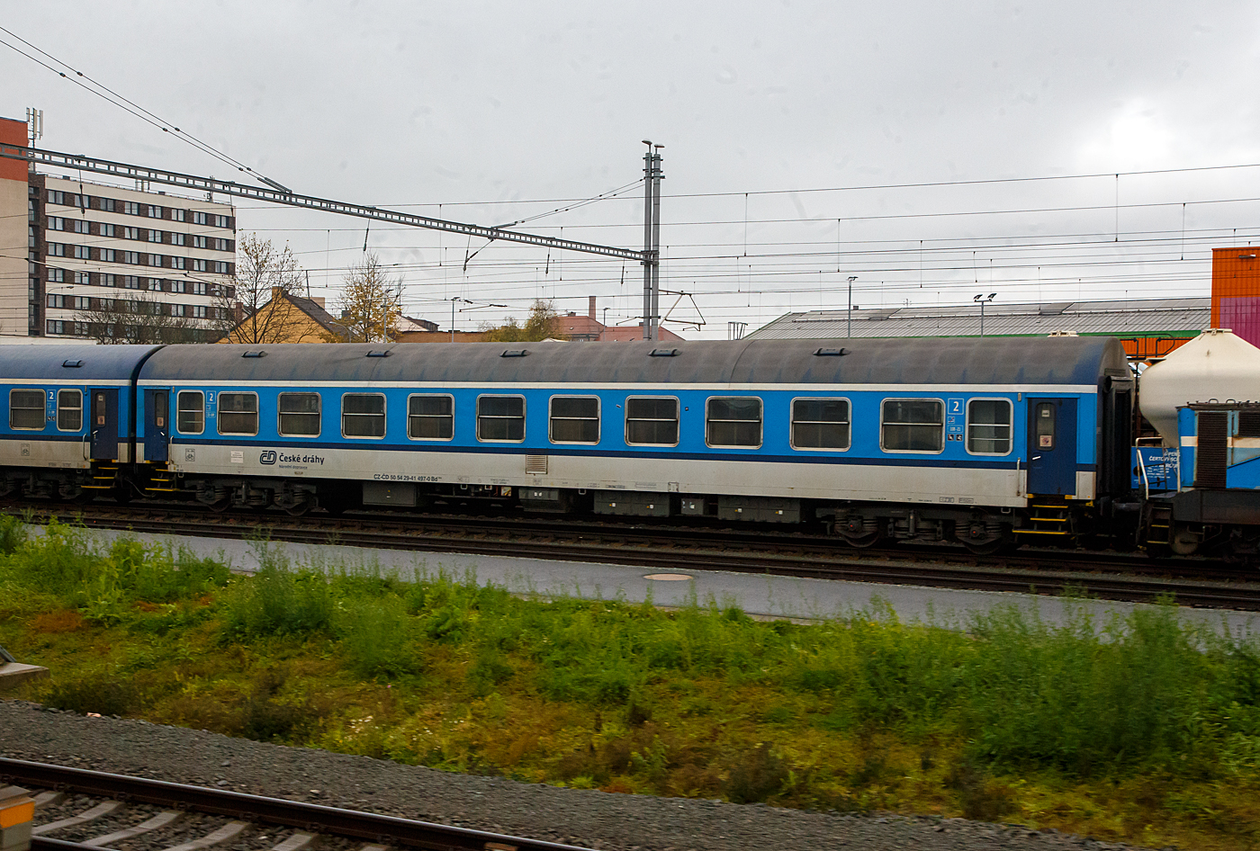 2. Klasse Abteil-Reisezugwagen mit Fahrrad-und Gepäckabteil CZ- ČD 50 54 29-41 497-0 der Gattung Bd 264 der ČD - České dráhy (Tschechische Bahnen) am 24.11.2022 bei Pilsen (Plzeň).

Diese Abteilwagen wurden 1977 bis 1985 vom VEB Waggonbau Bautzen gebaut und 2010/11 durch ŽOS ATECO Bubny modernisiert. 

TECHNISCHE DATEN:
Spurweite: 1.435 mm (Normalspur)
Achsanzahl: 4
Länge über Puffer: 24.500 mm
Drehzapfenabstand: 17.200 mm
Leergewicht: 37  t
Höchstgeschwindigkeit: 140 km/h
Sitzplätze: 72 in 12 Abteilen der 2. Klasse (und 2 Klappsitze)
Fahrradstellplätze: 8
