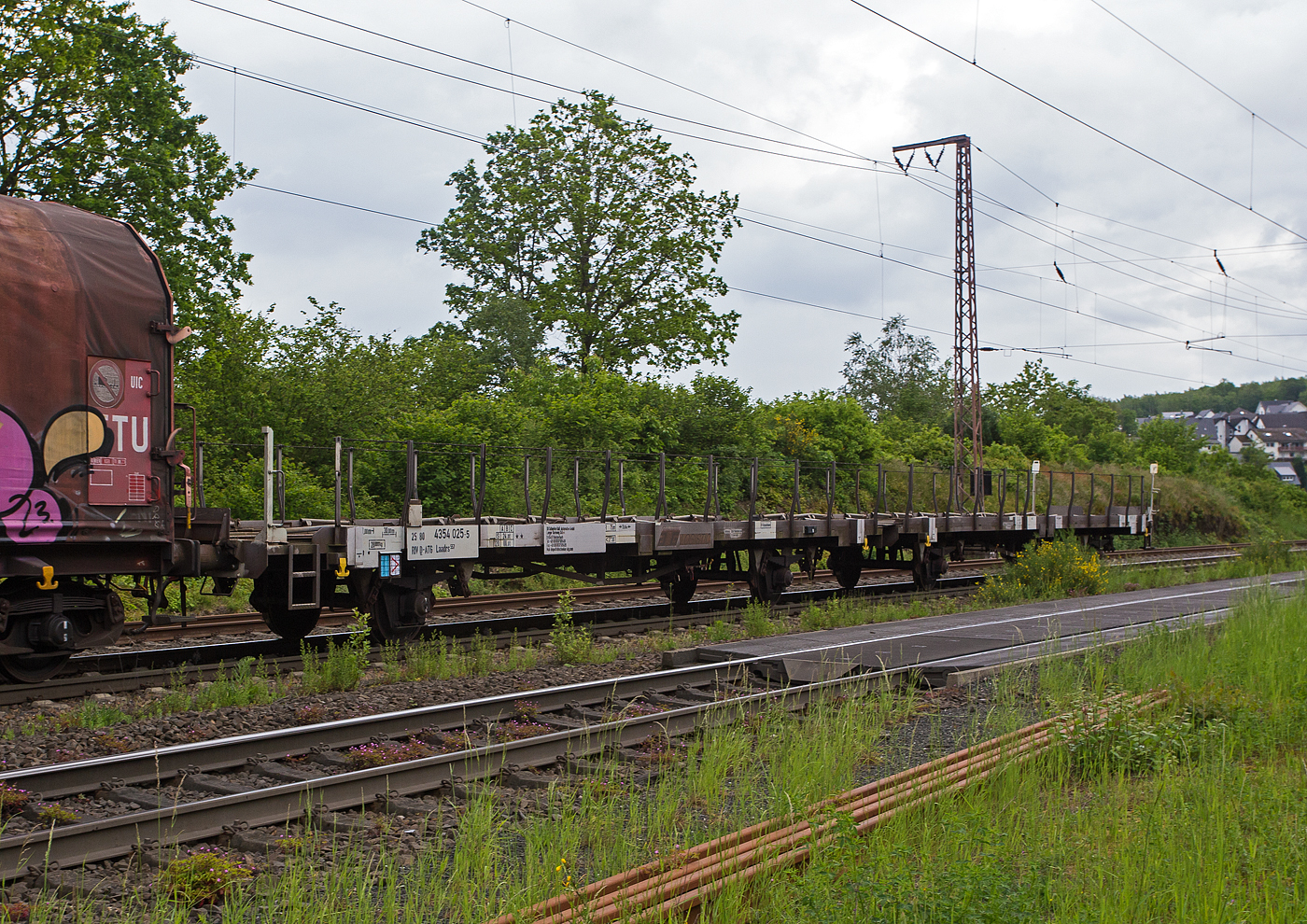 2 x 2 achsiger leere offener Autotransportwaggoneinheit 25 80 4354 025-5 D-ATG der Gattung Laadrs 557 der DB Cargo Logistics GmbH (ex ATG Autotransportlogistic GmbH) am 22 Mai 2024 im Zugverband bei der Zugdurchfahrt in Rudersdorf (Kreis Siegen).

Diese Wageneinheiten verfügen nur über eine Ladeebene und sind speziell für den europaweiten Transport von hohen Fahrzeugen wie beispielsweise Kleintransportern oder leichten Nutzfahrzeugen vorgesehen. Je nach Bauart können die Wagen mit 5 bis 6 Fahrzeugen beladen werden. Zur Ladungssicherung befinden sich auf der Ladeebene 48 Radvorleger. Diese Wagen wurden ab 1985 als Leks 558 gebaut und 1996 zu diesen Laadrs 557 umgebaut.

TECHNISCHE DATEN:
Gattung: Laadrs 557
Spurweite: 1.435 mm (Normalspur)
Anzahl der Achsen: 4 (2 x 2)
Länge über Puffer : 31.000 mm
Ladelänge : 30.000 mm
Höhe der Ladefläche über SOK: 1.165 mm
Achsabstände: 9.000 / 6.240 / 9.000 mm
Höchstgeschwindigkeit: 100 km/h (beladen) / 120 km/h (leer)
Eigengewicht: 28.000 kg
Nutzlast: 24,0  t ab Streckenklasse A 
Zulässige Radlast der Ladung (Transporter): 800 kg
Kleinster befahrbarer Gleisbogenhalbmesser: R =75 m
Bremse: KE-GP-A (LL)
Intern. Verwendungsfähigkeit: RIV
