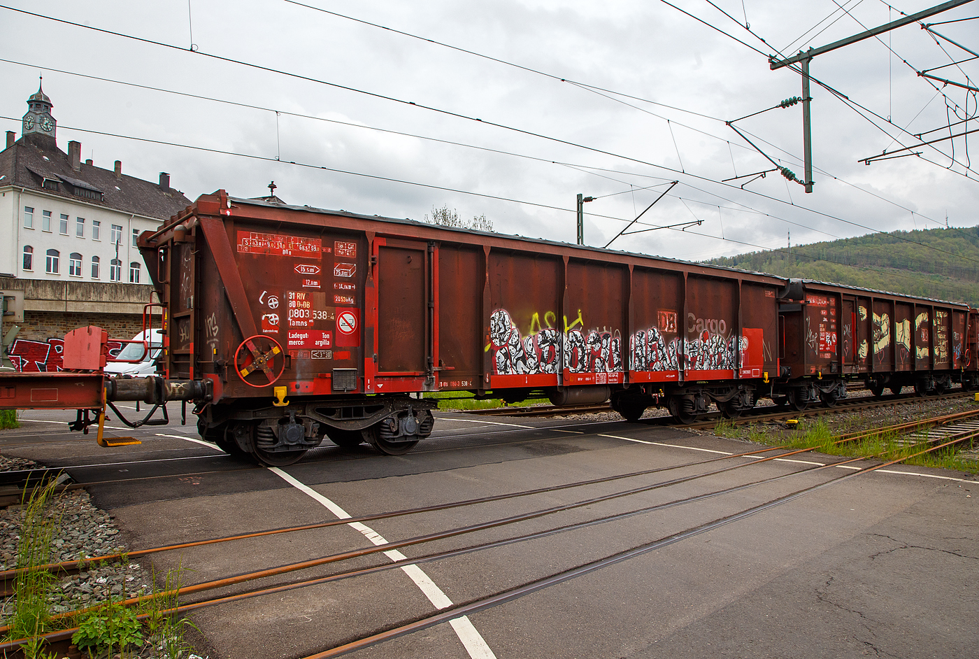 4-achsiger Drehgestell-Hochbordwagen mit Rolldach speziell f�r Tonerde, 31 80 0803 538-4 D-DB, der Gattung Tamns 895, der DB Cargo AG, am 11.05.2023 im Zugverband bei einer Zugdurchfahrt in Niederschelden.

Die Wagen werden speziell im Tonverkehr nach Italien eingesetzt,  z.B. von Siershahn (Westerwald) und L�hnberg (Lahn) �ber Frankfurt/M, Basel, Domodossola nach Dinazzano. Dort erfolgt der Umschlag f�r die Region Sassuolo als Schwerpunkt der keramischen Industrie Norditaliens.

Die als Tamns 895 bezeichneten Wagen beschafft die DB AG zwischen 1997 und 1999 bei der Konzern Tochter DB Waggonbau Niesky GmbH (ein Tochterunternehmen der DB Fahrzeuginstandhaltung GmbH). Sie besitzen ein neu entwickeltes Rolldach und haben nur eine schmale, einfl�gelige T�r je Wagenl�ngsseite. Das Kunststoff-Rolldach ist mit einem korrosionssicheren Zahnriemenantrieb ausgestattet und kann manuell �ber ein Handrad oder mittels eines Adapters auch maschinell bet�tigt werden.

Das Untergestell und der Wagenkasten sind Schwei�konstruktionen in Stahlbauweise unter Verwendung von Profilen, geschwei�ten Tr�gern und abgekanteten Blechen. In jeder Seitenwand ist eine einfl�gelige Dreht�r zum Begehen des Wagens integriert. Der Wagen hat einen 6 mm dicken Stahlfu�boden. 

Das Planendach besteht aus einem beschichteten Chemiefasergewebe, es wird durch Spriegel �ber dem Wagenkasten gehalten. Das Planenmaterial ist witterungsunempfindlich, UV-best�ndig und auch bei tiefen Temperaturen noch elastisch. Die Dachbet�tigung erfolgt �ber ein Handrad in Stirnwandn�he. Hierbei wird �ber ein Untersetzungsgetriebe eine Welle angetrieben, die zwei im Oberrahmen befindliche Endloszahnriemen bewegt. An den genau parallel laufenden Zahnriemen sind Nocken aufgesetzt, die beim �ffnungsvorgang die Spriegel des Daches mitnehmen. Die Verriegelung des Daches erfolgt �ber Sperren an den Handr�dern.

TECHNISCHE DATEN:
Spurweite: 1.435 mm (Normalspur)
L�nge �ber Puffer: 14.040 mm
Drehzapfenabstand: 9.000 mm
Gesamter Radsatzstand: 10.800 mm
Achsabstand im Drehgestell: 1.800 mm
Eigengewicht: 20.530 kg
Maximales Ladegewicht: 69,0 t ab Streckenklasse D3
Radsatzlast: 22,5 t
H�chstgeschwindigkeit: 120 km/h (leer) bzw. 100 km/h (beladen)
Kleinster befahrbarer Radius: 60 m
Ladefl�che: 35,5 m�
Laderaum: 75,4 m�
Ladel�nge: 12.772 mm
Ladebreite: 2.780 mm
Ladeh�he: 2.124 mm
Seitenwand-T�r�ffnung (B � H): 890 � 1.800 mm
Lichte �ffnung bei ge�ffnetem Dach: 12.772 � 2.630 mm
Wagenh�he: 3.462 mm
Drehgestell-Bauart: Y25 Lsd 1
Bauart der Bremse: KE-GP-A (LL)
Bremssohle: IB 116 (C952-1)

Hersteller: DB Waggonbau Niesky GmbH