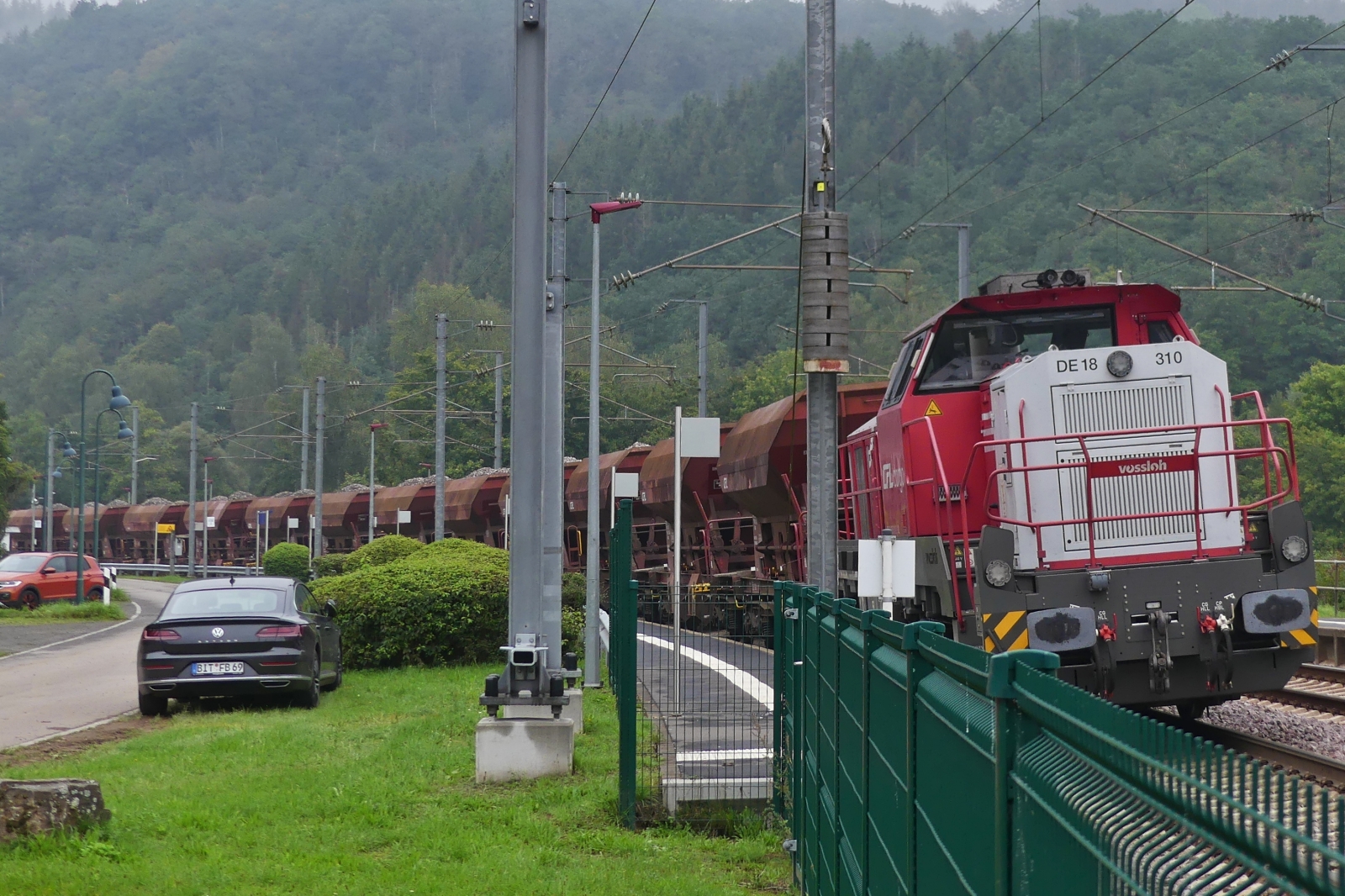 CFL DE 18 310 steht mit gefüllten Schotterwagen der Gattung Uads am Bahnsteig in Drauffelt. 29.08.2023