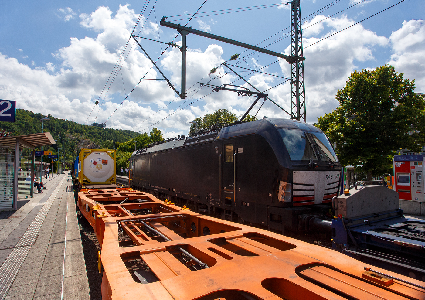 Da bin ich am 16 Juli 2025 gerade noch mit den Güterwagen der in Richtung Siegen fahrenden DB 187 123 beschäftigt, da kommt in Gegenrichtung (Köln) die an die HELROM GmbH (Frankfurt am Main) vermietete SIEMENS Vectron MS X 4 E – 644 / 193 644-2 (91 80 6193 644-2 D-DISPO) der Beacon Rail Capital Europe GmbH, München (BRCE / DISPO), mit dem HELROM Trailer Zug Wien – Düsseldorf, einem besonderen KV-Zug, durch den Bahnhof Kirchen/Sieg. So blieb mir nur noch, sie über den leeren Sgmmns-Wagen, sie abzulichten. 

Die Siemens Vectron MS - 6.4 MW wurde 2016 von Siemens in München-Allach unter der Fabriknummer 22168 gebaut. Sie ist in der Variante A09 ausgeführt und hat so die Zulassungen für Deutschland, Österreich und Italien (D / A / I). Sie hat eine Höchstgeschwindigkeit von 160 km/h.

Die Lok wurde an die MRCE - Mitsui Rail Capital Europe GmbH in München ausgeliefert, seit September 2023 hat die Beacon Rail Metro Finance B.V. die Mitsui Rail Capital Europe B.V. (Amsterdam) und somit auch die Mitsui Rail Capital Europe GmbH im München übernommen, so firmiert sie nun als Beacon Rail Capital Europe GmbH, München (BRCE / DISPO).