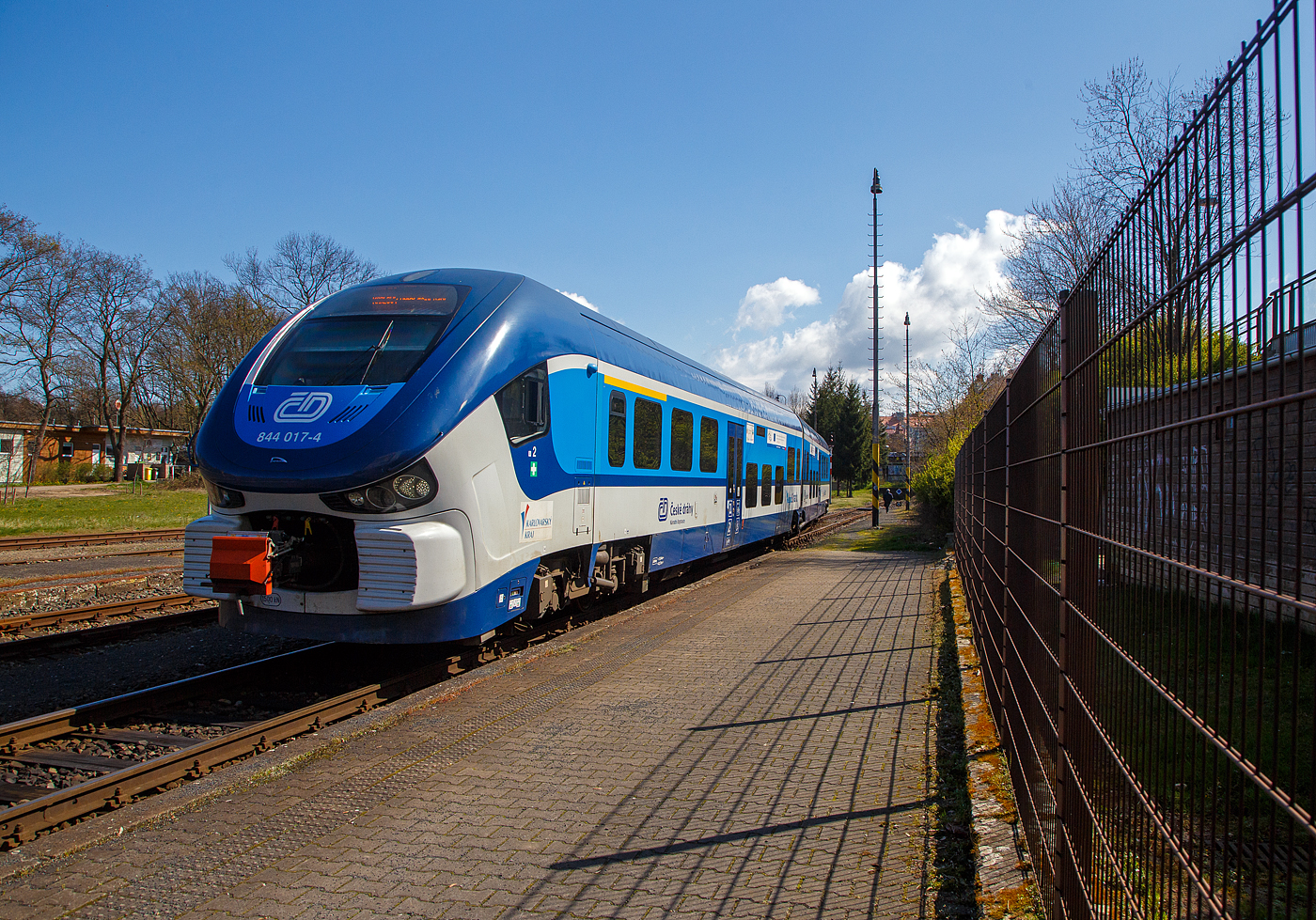 Der ČD „RegioShark“  844 017-4 (CZ-ČD 95 54 5 844 017-4), ein Dieseltriebzug vom Typ PESA LINK II (Pesa 223M), erreicht am 19.04.2023 als Os 17113 von Johanngeorgenstadt (Sachsen) kommend den Zielbahnhof Karlovy Vary doln� n�dra�� (Karlsbad unterer Bahnhof). Kurz nach der Ankunft f�hrt er dann als Os 17138 �ber (den oberen Bahnhof) Karlovy Vary nach Nove Hamry (Neuhammer).

Die Fahrzeuge setzen sich aus zwei weitgehend identischen H�lften zusammen, die �ber ein nicht angetriebenes Jakobsdrehgestell verbunden sind. Angetrieben werden die beiden �u�eren Drehgestelle �ber zwei MTU-Powerpacks, vom Typ MTU 6H 1800 R85Lmit je 390 kW Leistung, die unter dem Wagenfu�boden angeordnet sind. Die Leistungs�bertragung erfolgt jeweils mittels hydromechanischen Getriebes auf jeweils beide Achsen der Triebdrehgestelle. Bei Strecken mit Steigung h�rt man im Innenraum sehr stark wie die Motoren arbeiten m�ssen, ansonsten sind die Fahrzeuge aber sehr Laufruhig.

Zwischen den Drehgestellen ist der Fahrgastraum niederflurig ausgef�hrt, sodass an Bahnsteigen mit einer H�he von 550 Millimetern �ber Schienenoberkante ein barrierefreier Einstieg gew�hrleistet ist. Der Fahrgastraum ist klimatisiert. 

TECHNISCHE DATEN:
Anzahl: 31 
Hersteller: PESA, Bydgoszcz, Polen
Spurweite: 1.435 mm (Normalspur)
Achsformel: B'2'B'
L�nge �ber Kupplung:  43.730 mm
Achsstand im Drehgestell:  2.100 mm
H�he:  4.185 mm
Breite: 2.900 mm
Gewicht: 86 t
H�chstgeschwindigkeit: 120 km/h
Motoren: 2 St�ck MTU Unterflur-Powerpack  6H 1800 R85L
Installierte Leistung: 2 x 390 kW
Leistungs�bertragung: hydromechanisch (Voith-Diwa-Getriebe) 	
Kupplungstyp: Scharfenberg
Sitzpl�tze: 120 (9 in der 1. und 111 in der 2. Klasse)
