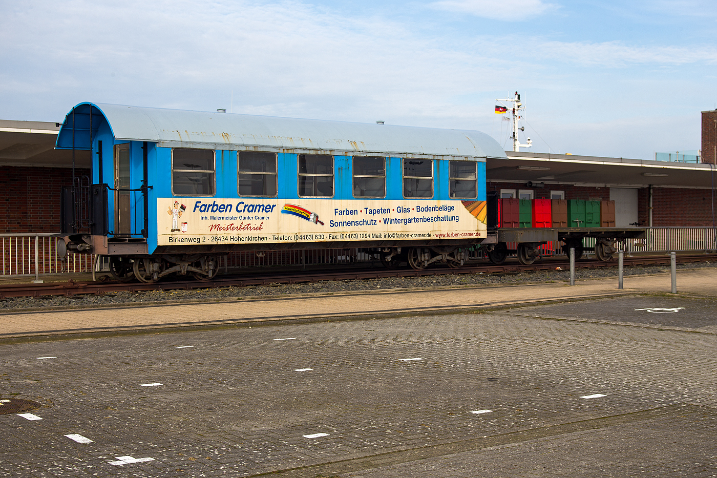 Der Denkmalwagen 63 109 ein vierachsiger schmalspuriger Drehgestell-Personenwagen mit zwei offenen Plattformen der 2. Wagenklasse DB 63109 der DB Fernverkehr AG (Wangerooger Inselbahn / SIW - Schifffahrt und Inselbahn Wangerooge) am 14 März 2024 beim Fährterminal (ehem. Bahnhof) Harlesiel. Rechts davor ein zweiachsiger unbekannter Flachwagen. 

Der Personenwagen wurde 1913 von der Düsseldorfer Eisenbahnbedarf AG, vorm. Carl Weyer & Cie. gebaut. Er war aber damals, für den raschen Fahrgastwechsel an den Anlegern, als Abteilwagen mit vielen Türen ausgeführt.

Lebenslauf:
1913 Auslieferung an GOE - Großherzoglich Oldenburgische Eisenbahnen als „Oldenburg 9“
01.04.1920 DR - Deutsche Reichseisenbahnen „Oldenburg 9“
31.08.1924 DRG - Deutsche Reichsbahn-Gesellschaft „Old 9“
01.01.1935 Umzeichnung in „Mst 9“
02.02.1937 DRB - Deutsche Reichsbahn „Mst 9“
1945 Abstellung, da schadhaft (ggf. d. Bombenangriff), Wagenkaten nicht wiederherstellbar.
07.09.1949 DB - Deutsche Bundesbahn „Mst 9“
31.12.1949 Ausmusterung
31.05.1950 Umbau durch BW Wangerooge „Mst 9“
Entfernung der beschädigten Seitenwände, Dachreparatur, neue Holzsitze. Nutzung als offener Sommerwagen. 
14.11.1955 Umzeichnung in „Mst 18“
1956 z-Stellung
1959 Umbau durch das AW Limburg (Lahn)
Neuaufbau des Wagenkastens (in die heutige Form) mit Teilen des laufenden yg-Umbauwagenprograms. Umzeichnung wieder in DB „Mst 9“
1965 Umzeichnung in „Mst 109“
01.04.1972 Umzeichnung in „Han109“ 
1988  Umzeichnung in DB 63 109
1992 Abstellung (Überführung ins Raw Wittenberge)
1997 Aufstellung als Denkmal in Harlesiel
2007 Äußerliche Aufarbeitung in der aktuellen Farbgebung der Inselbahn
2008 Innerliche Aufarbeitung im aktuellen Design der Schiffe. 2 ½ Reihen der Sitzbänke sind erhalten geblieben, der übrige Bereich dient als Besprechungsraum für 8 bis 10 Personen.

TECHNISCHE DATEN:
Spurweite:  1.000 mm (Meterspur)
Anzahl der Achsen: 4 (2´2´)
Länge über Puffer: 12.100 mm
Drehzapfenabstand: 7.500 mm
Achsabstand: im Drehgestell: 1.300 mm
Breite: 2.650 mm
Höhe: 3.565 mm
Sitzplätze (vor Umbau): 48
